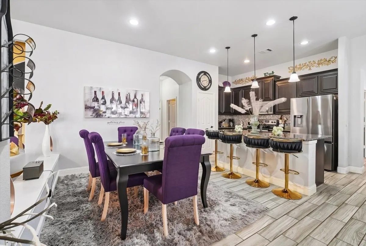Kitchen featuring dark wood-finish cabinetry, stainless steel appliances, and a breakfast bar with pendant lighting