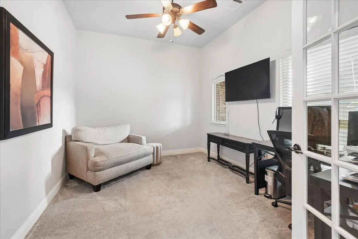 Vaulted ceiling with a ceiling fan, carpet flooring, windows with blinds, and French doors