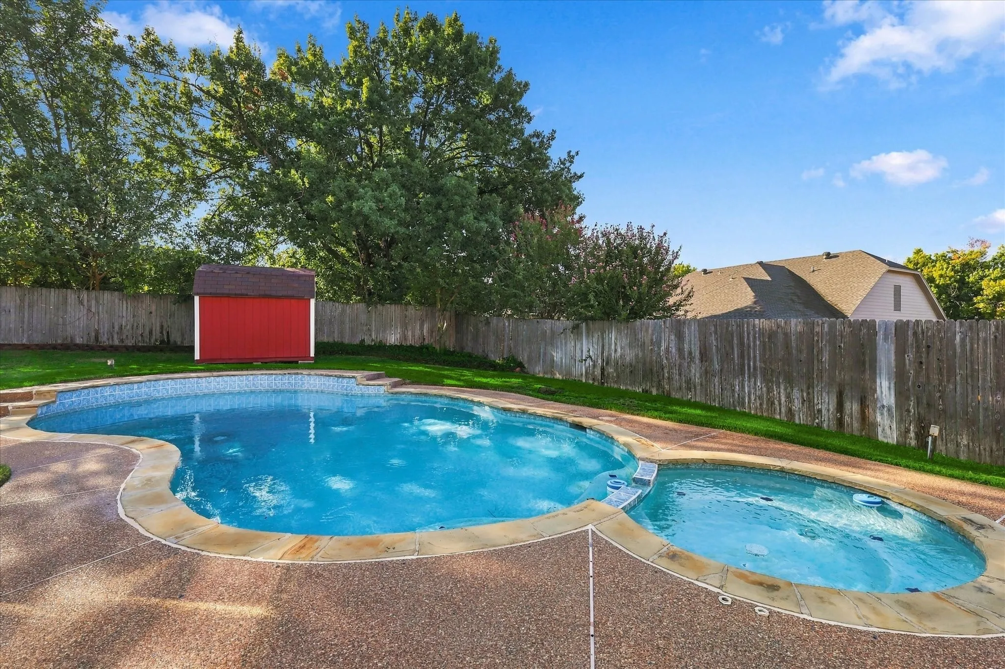 Swimming pool with integrated spa and stone coping