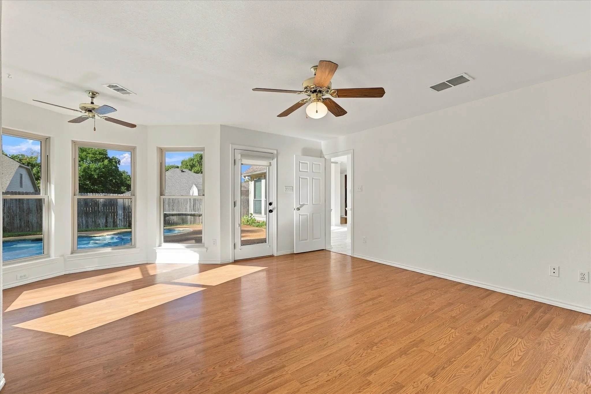 Wood-finish flooring throughout, multiple windows, and a glass-paneled door