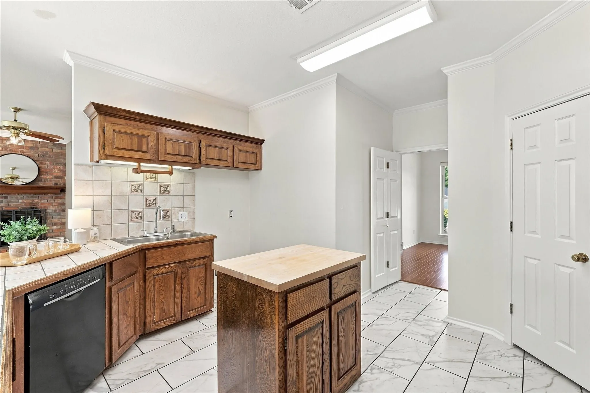 Kitchen featuring wood cabinetry, a tile backsplash, and a center island. Island is movable.