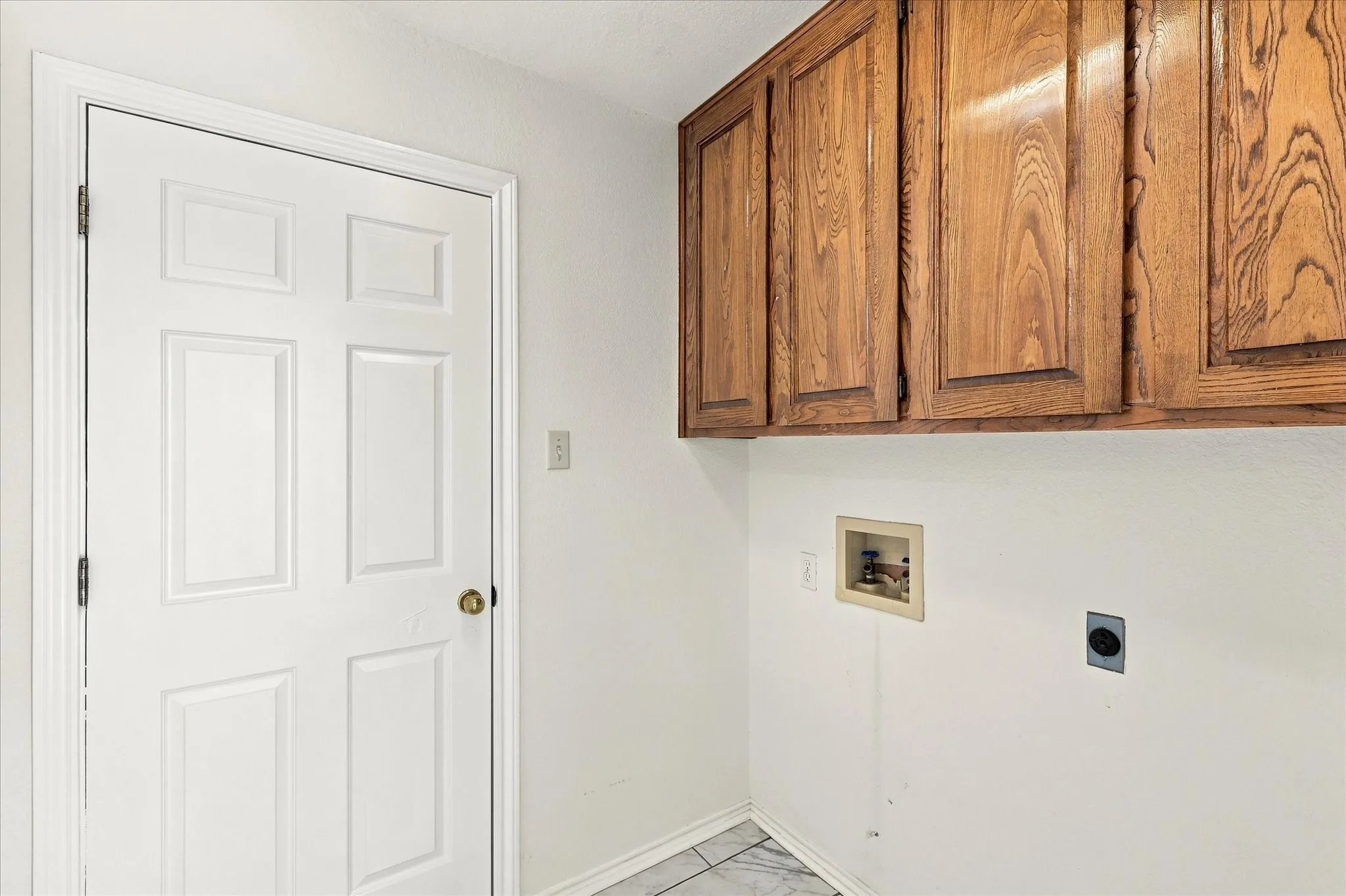 Integrated wood-finish cabinetry, white paneled door, and tile flooring
