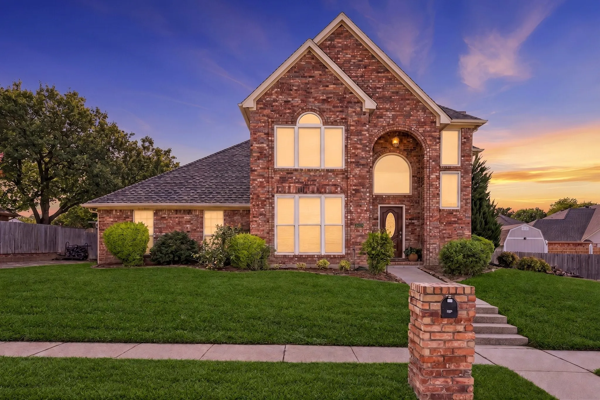 Brick exterior featuring a gabled roofline, arched entry, and prominent windows