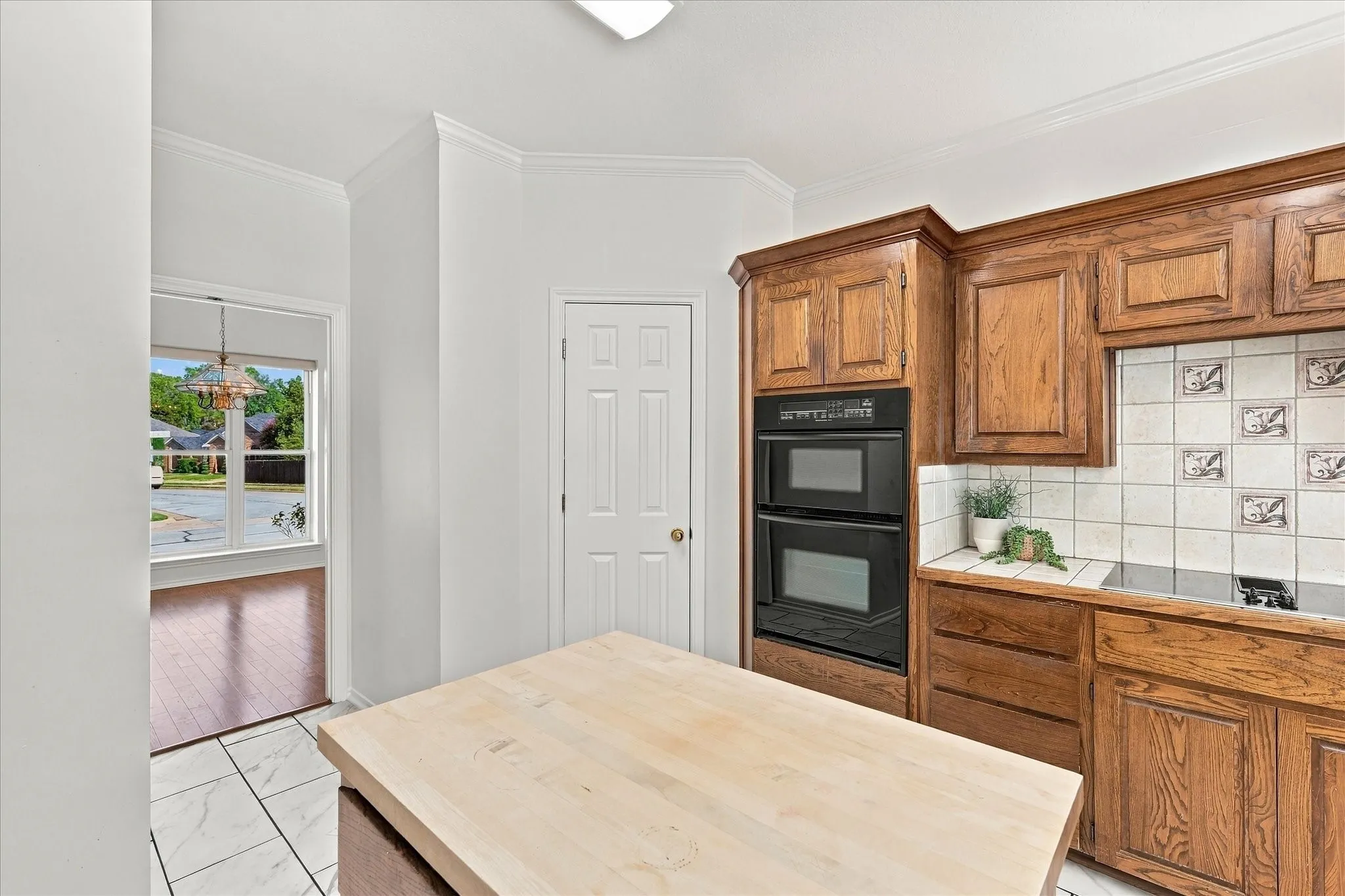 Kitchen featuring wood cabinetry, a built-in double oven, and a tile backsplash