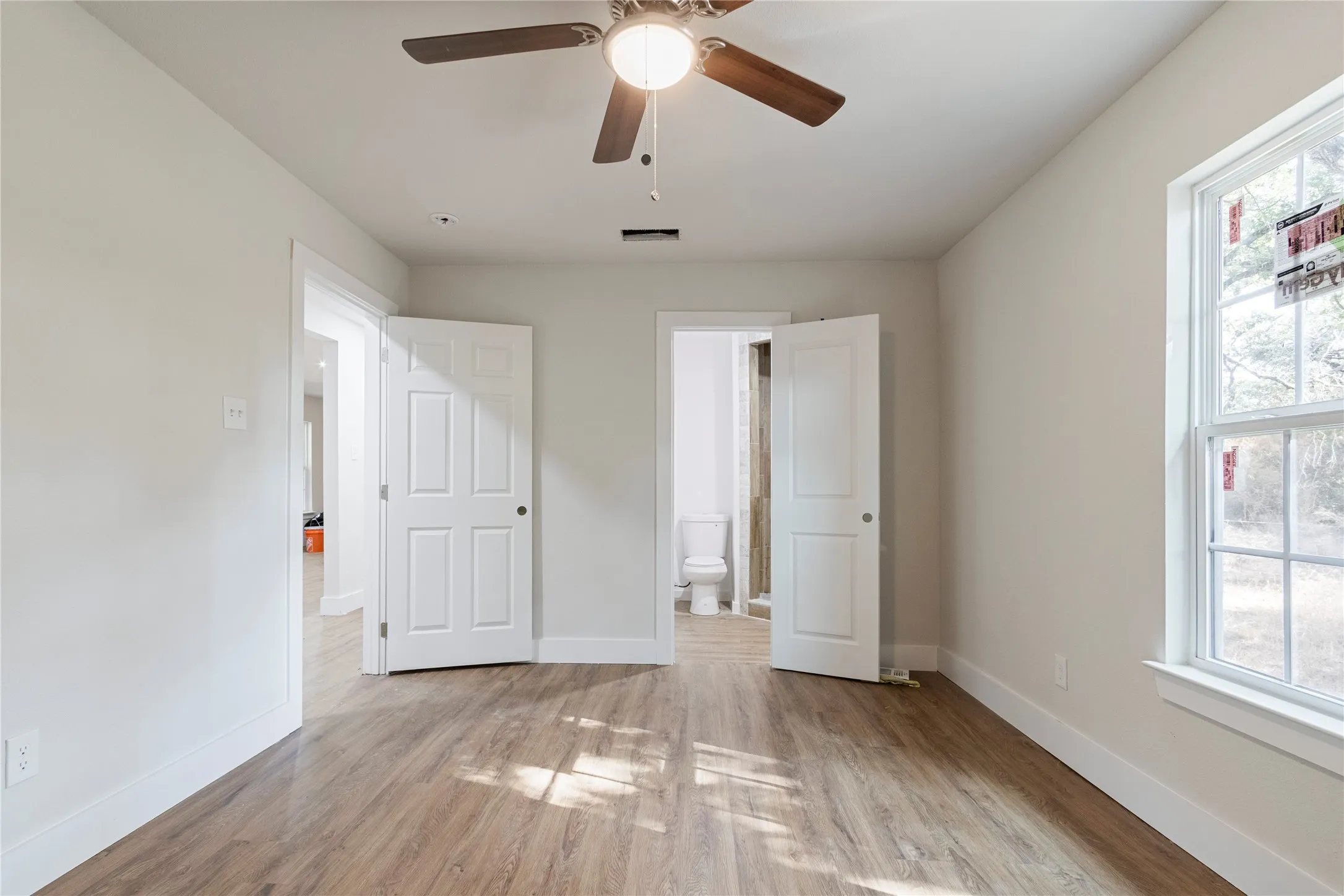 Spacious interior with wood-finish flooring, white trim, and light-colored walls