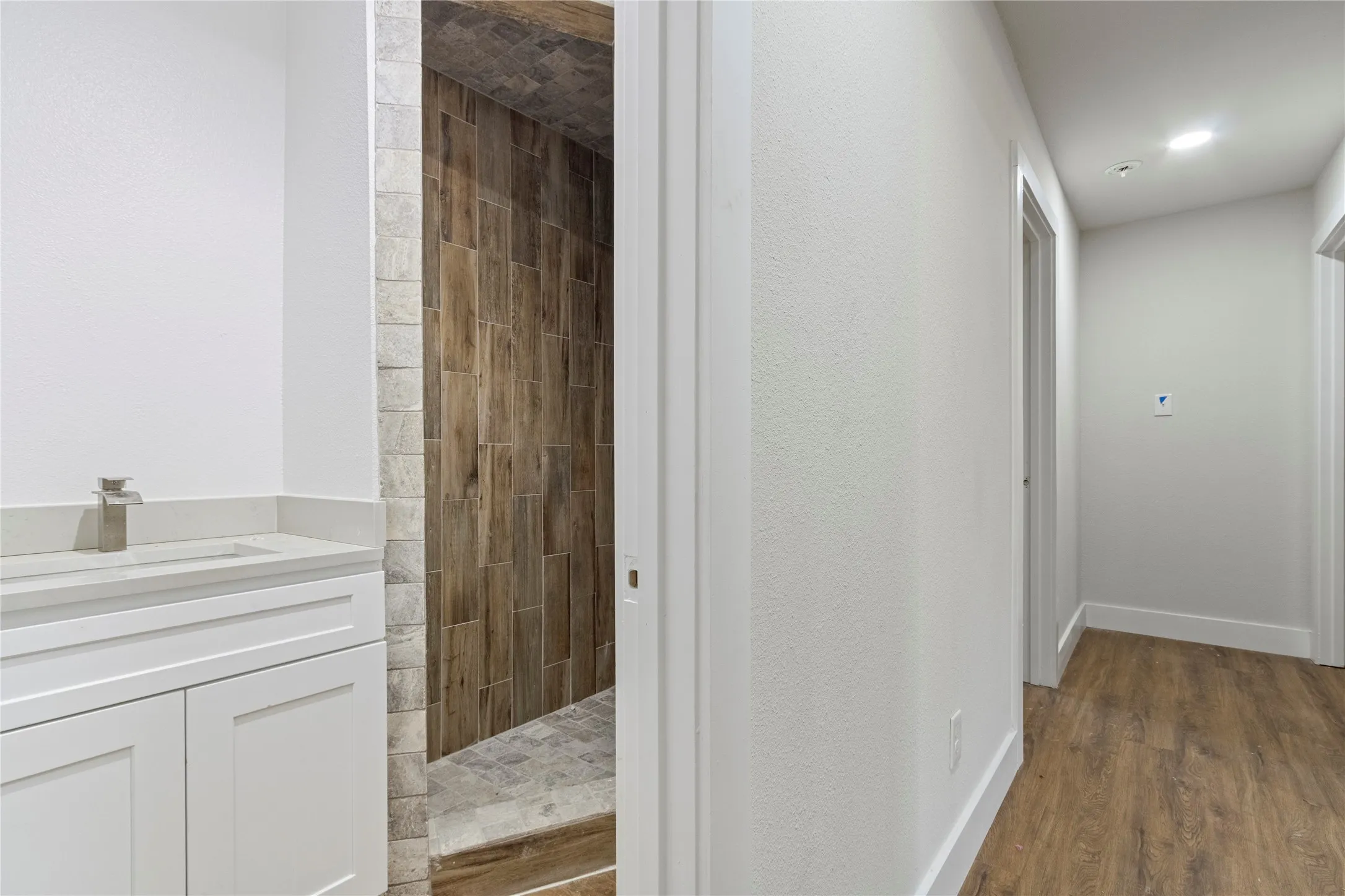 White vanity with integrated sink and brushed nickel faucet
