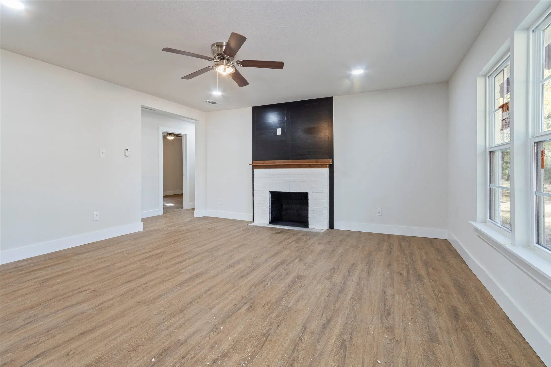 Recessed lighting, wood-finish flooring, and a ceiling fan with light fixture