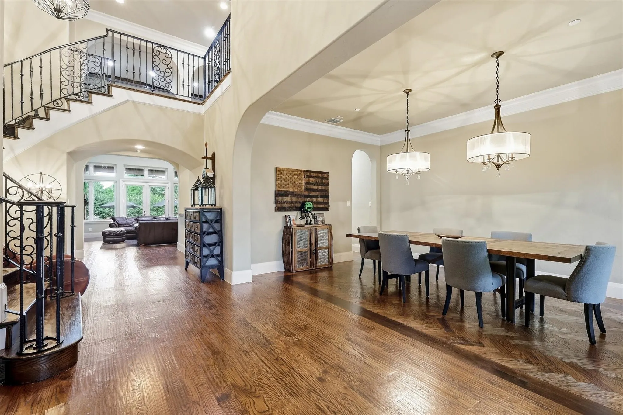 Spectacular view of the winding staircase, dedicated dining area, with herringbone inlaid flooring & living room