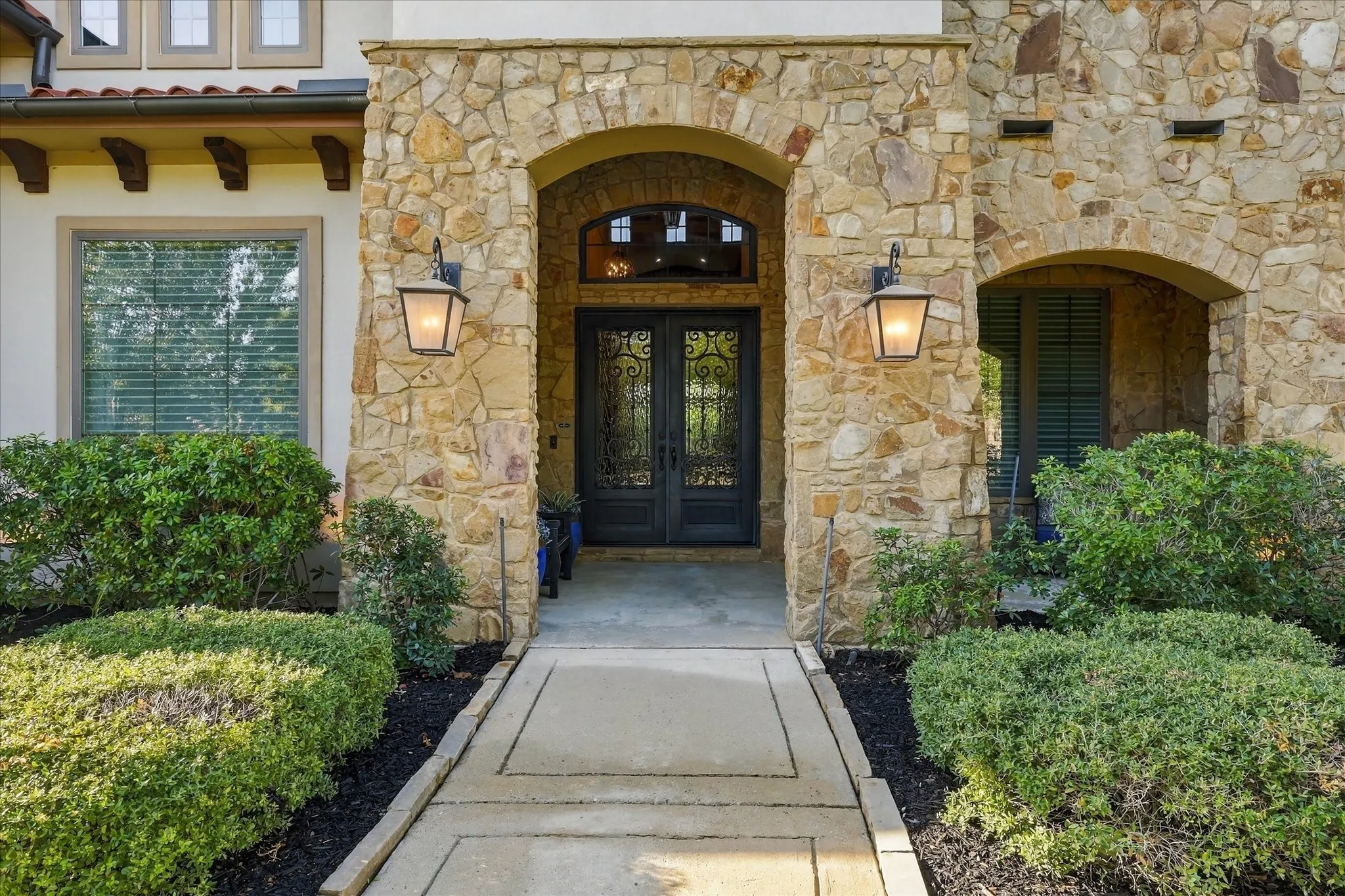 Beautiful, grand double iron front doors with operable translucent glass panels make for a grand entrance