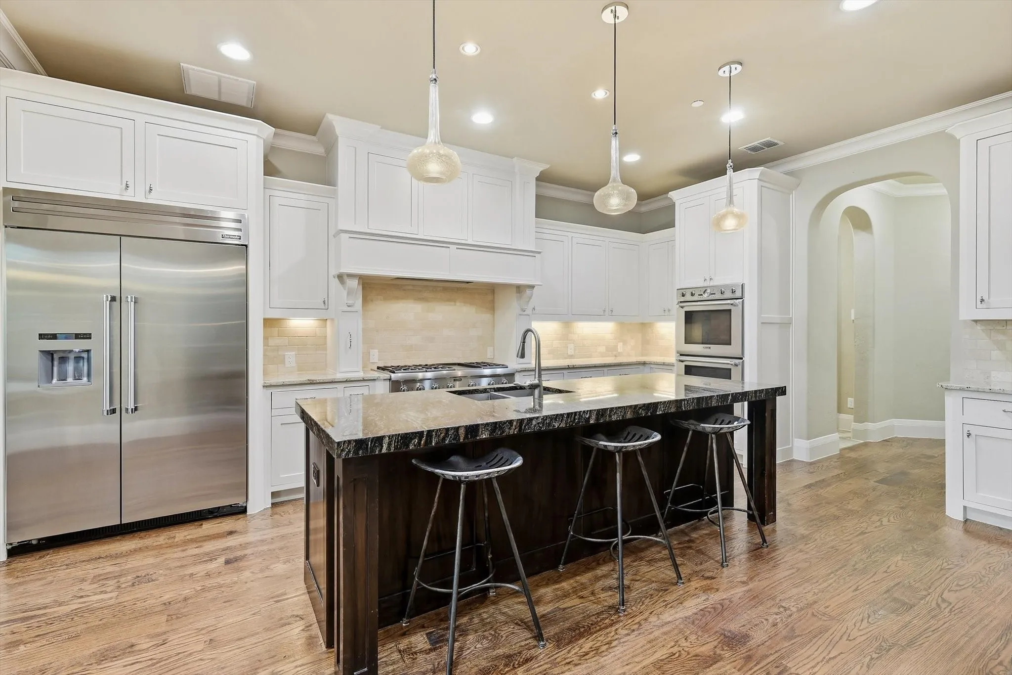 Thermador appliances . Built in fridge , and a view of the cooktop