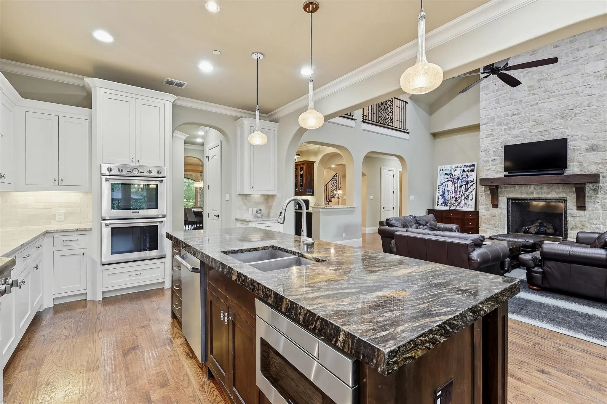 Full view of the stainless steel appliances including double ovens and undercounter microwave.