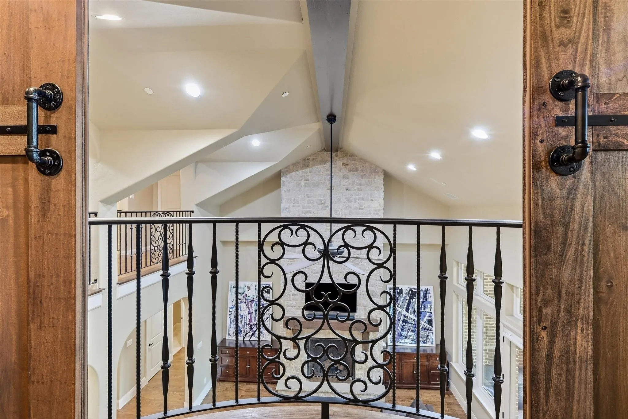 Julietta Balcony on upper floor. Closes off with riich wooden barn doors looking over the great room down and stone fireplace