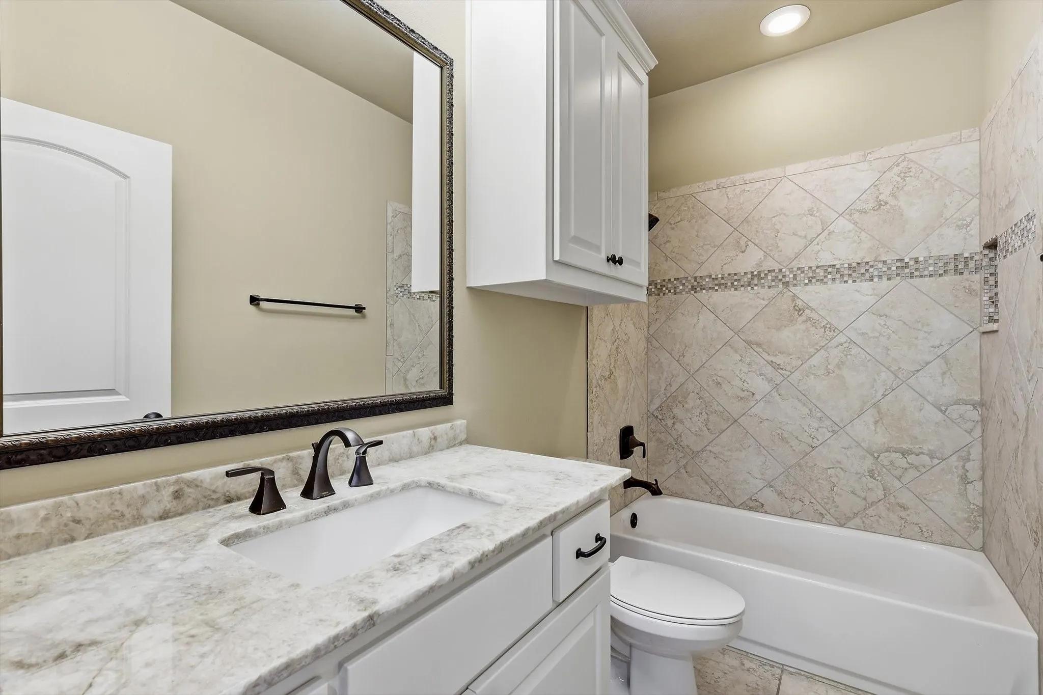 En suite bath up. Granite counters. Large mirror, medicine cabinet. Tub plus shower and decorative tile