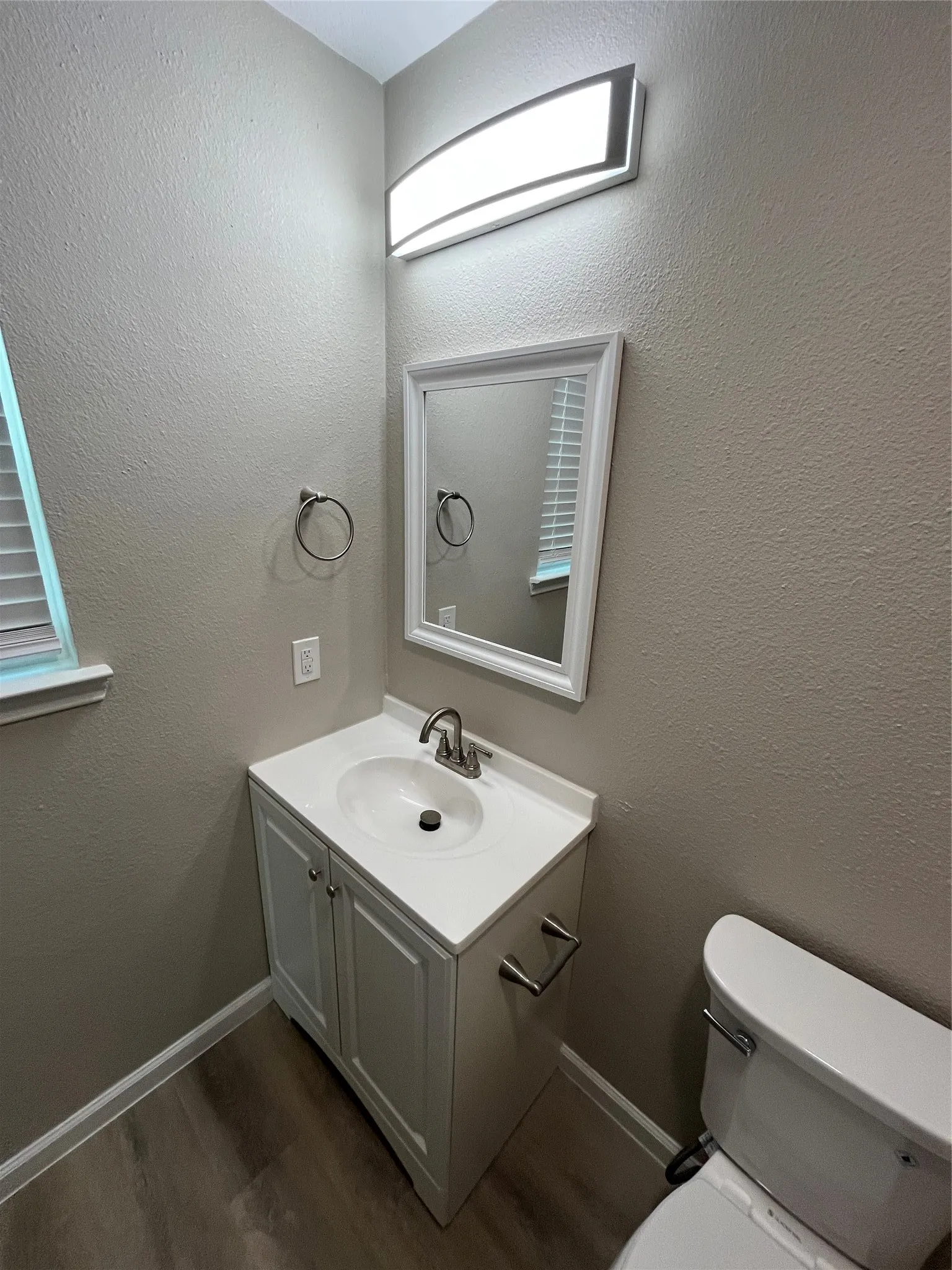 Contemporary vanity with integrated sink, brushed nickel faucet, and framed mirror