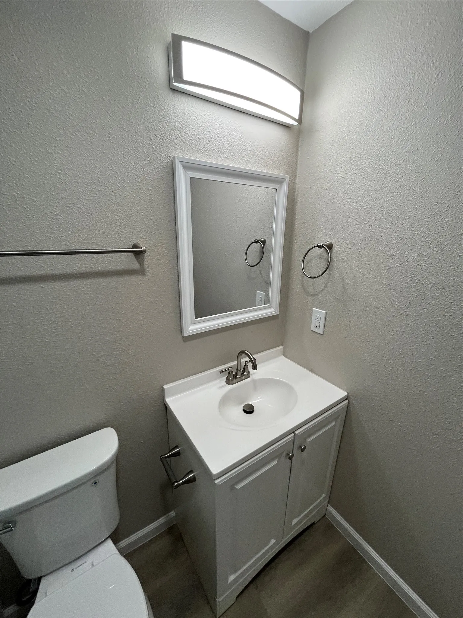 White vanity with a single basin sink and brushed nickel faucet