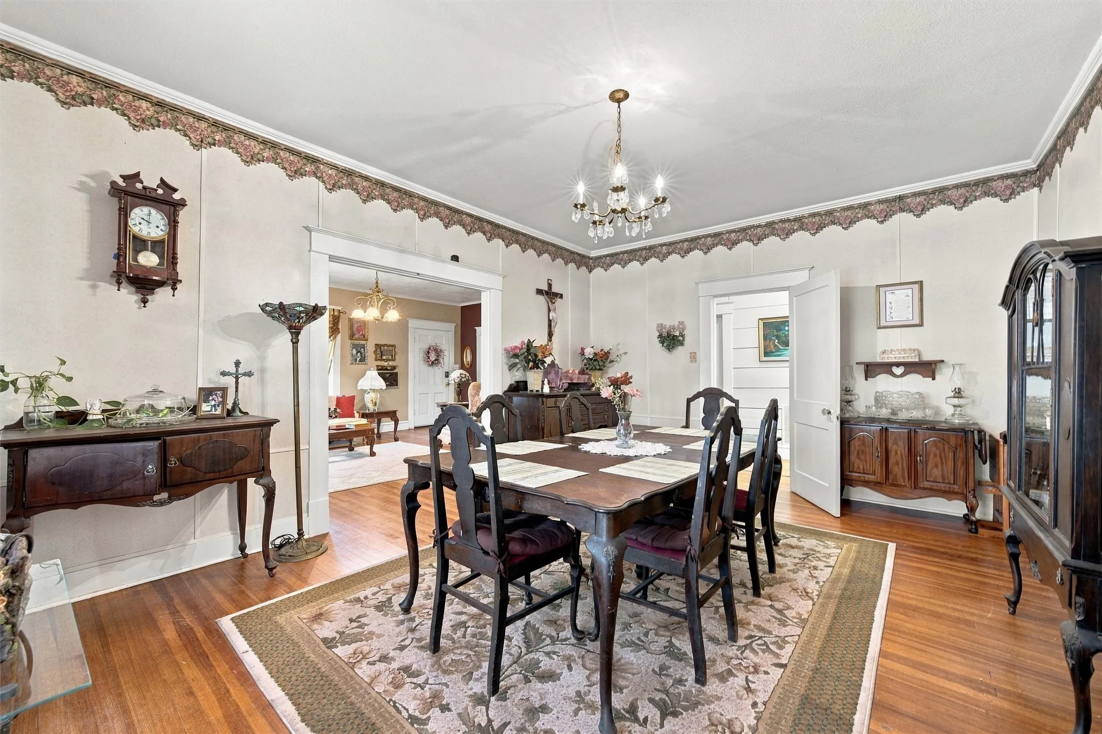 Hardwood flooring, chandelier lighting, and a wide doorway opening