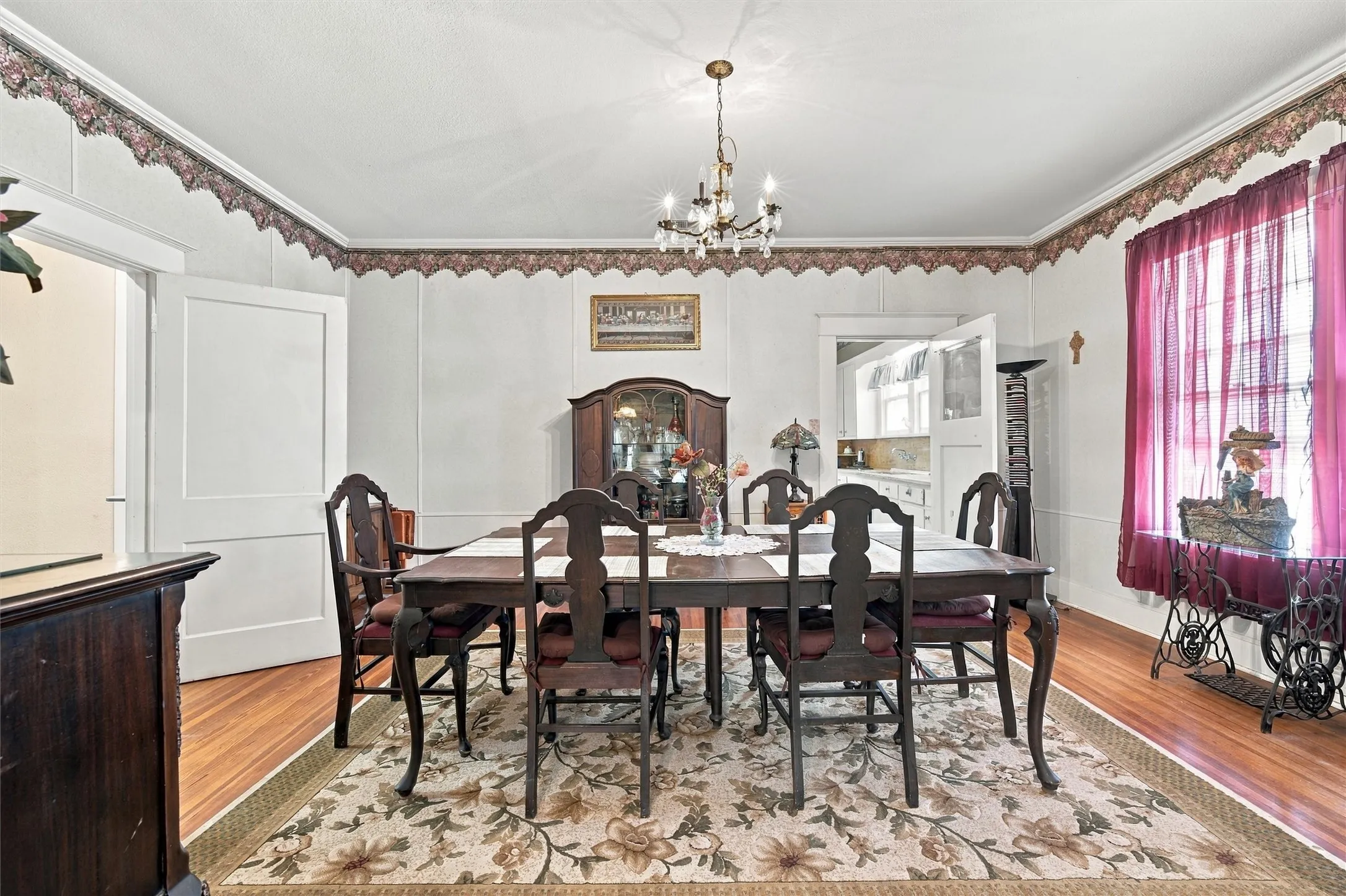 Hardwood flooring throughout, crown molding, and a chandelier lighting fixture