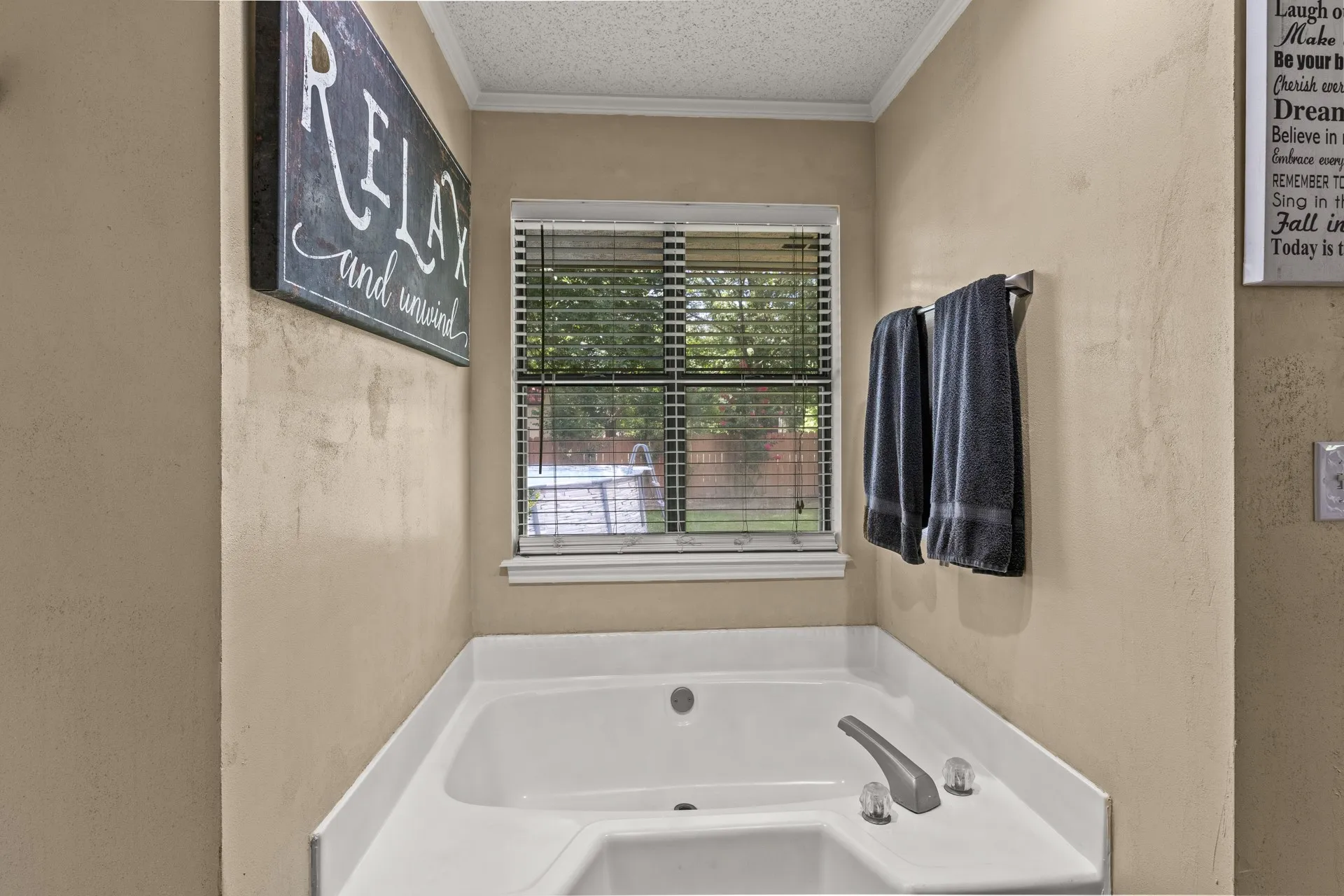 Bathroom featuring a jetted tub and crown molding