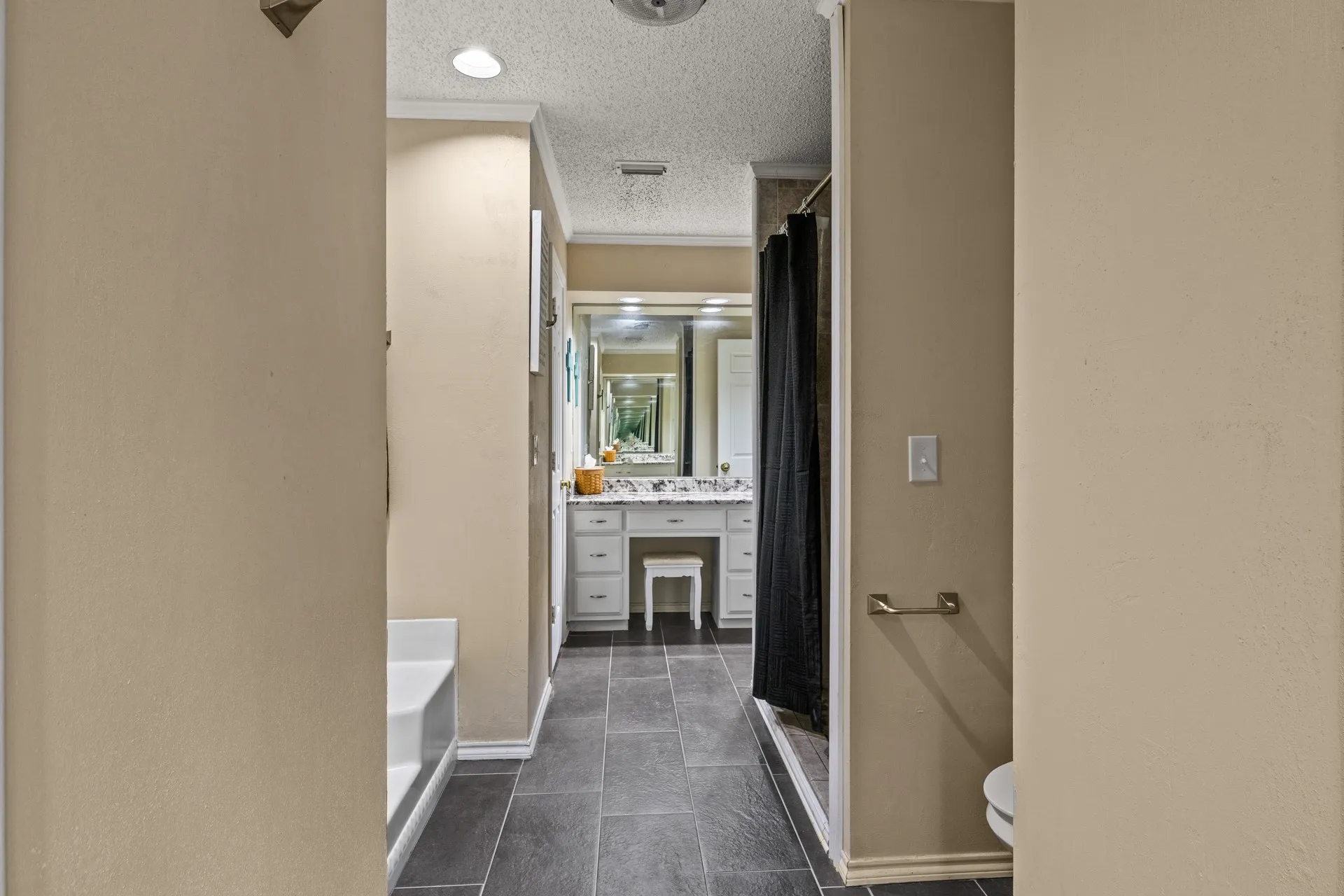 Full bath featuring crown molding, vanity, a textured ceiling, a shower with curtain, and a bath
