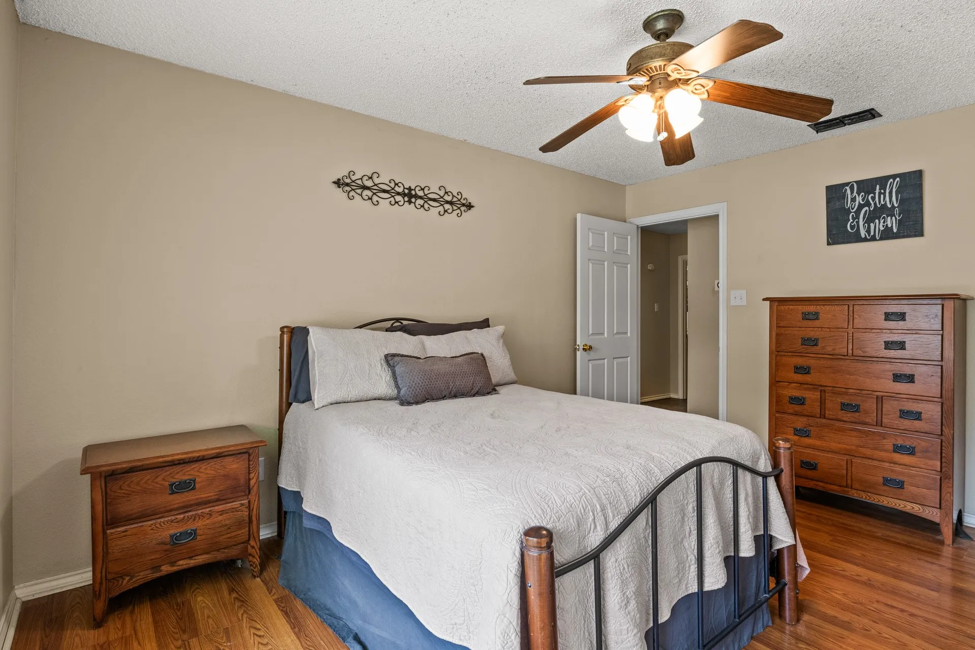 Bedroom featuring wood finished floors, a textured ceiling, and ceiling fan