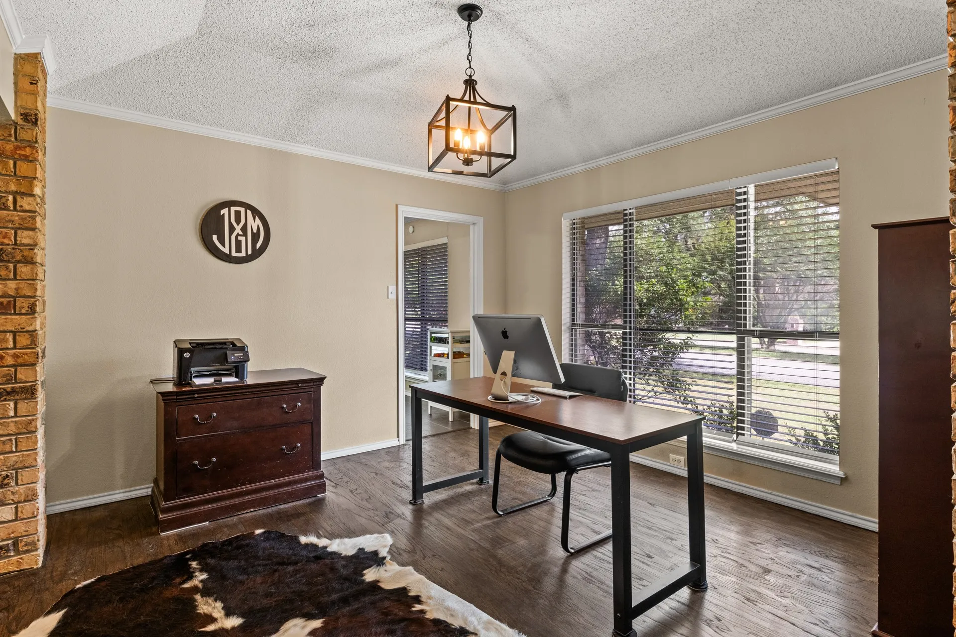 Office space featuring a textured ceiling, a chandelier, dark wood-type flooring, and crown molding