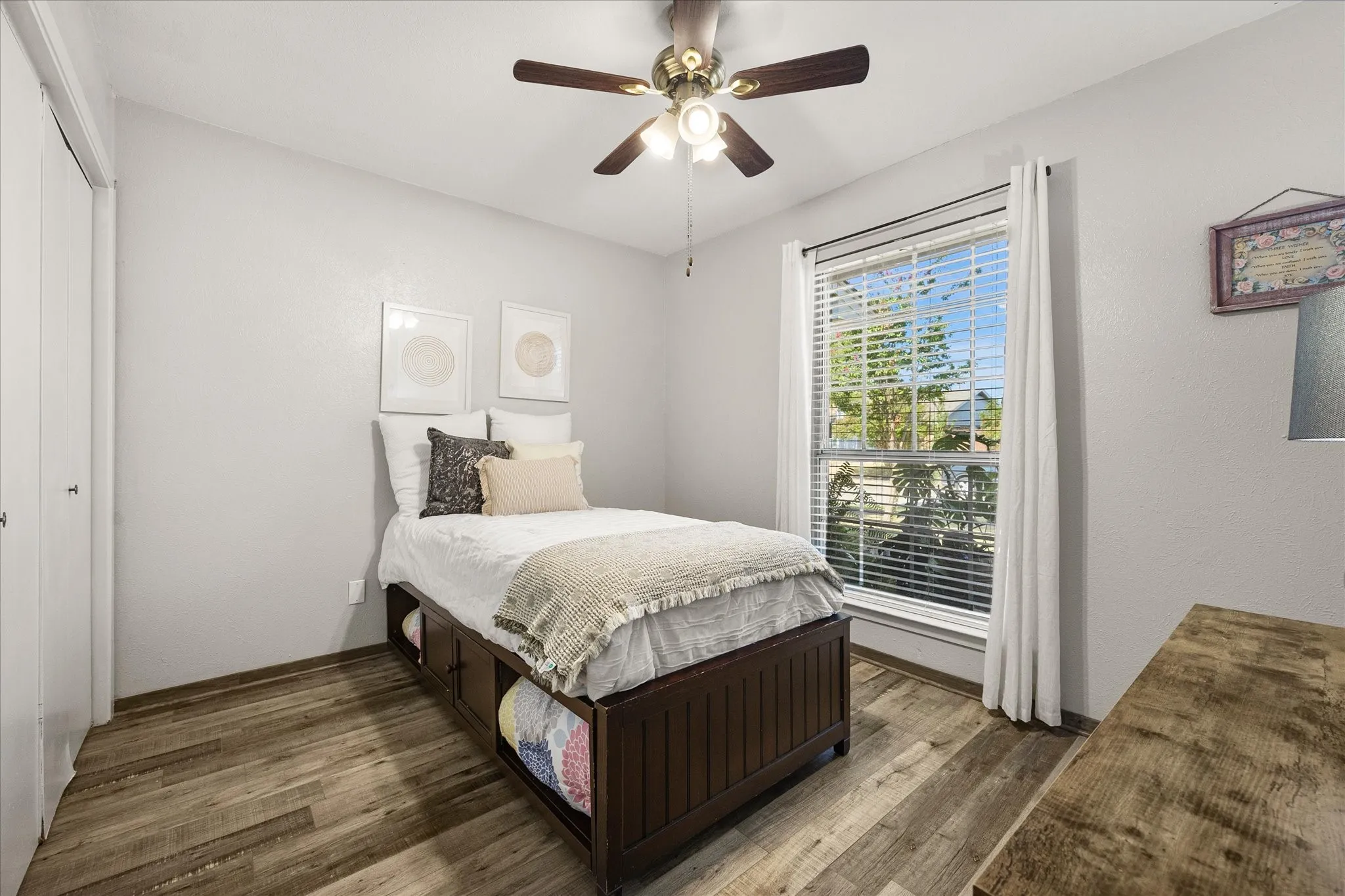 Wood-finish vinyl plank flooring with a ceiling fan light fixture