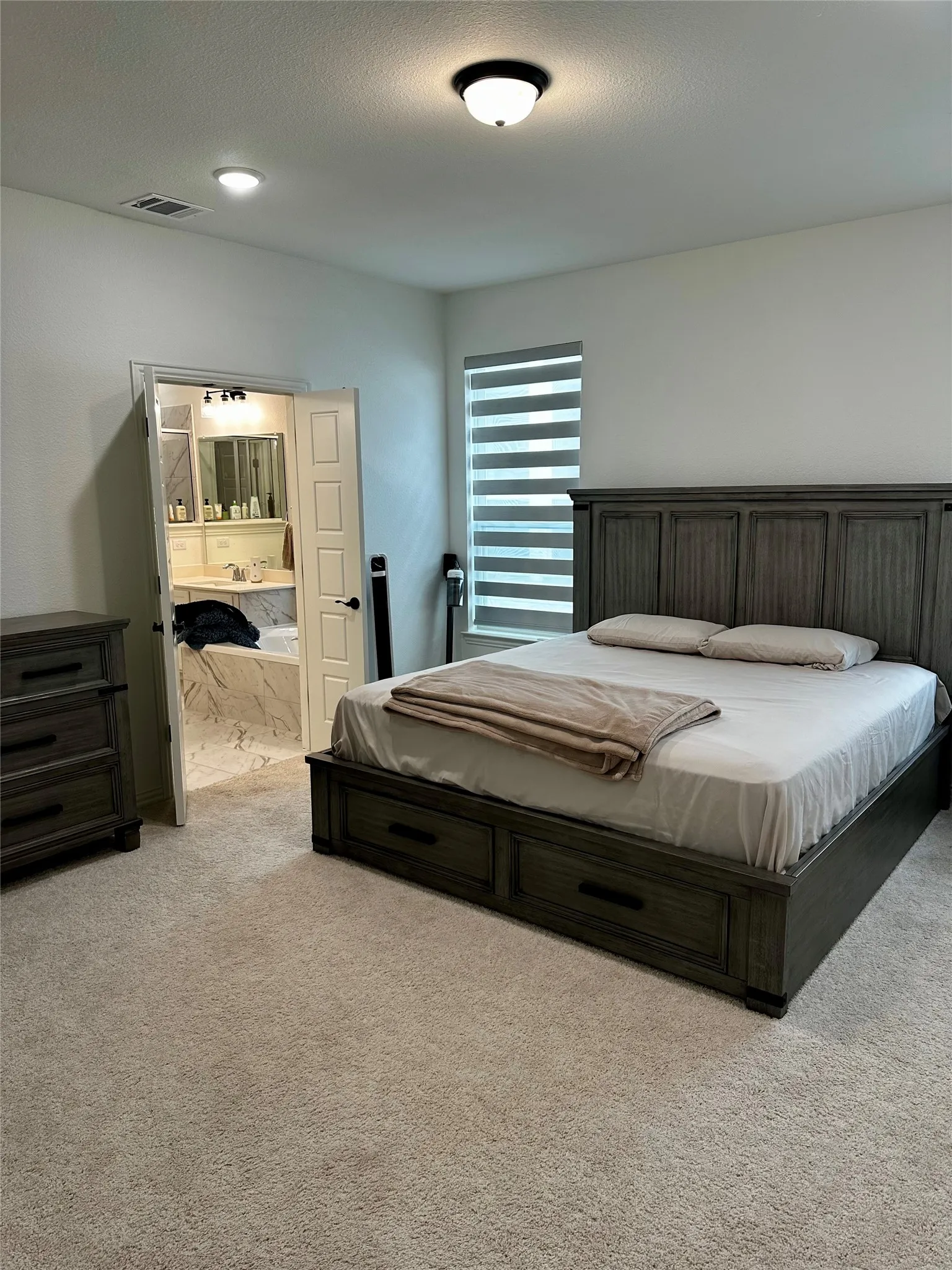 Plush carpeting, a drum light fixture, and a window with horizontal blinds