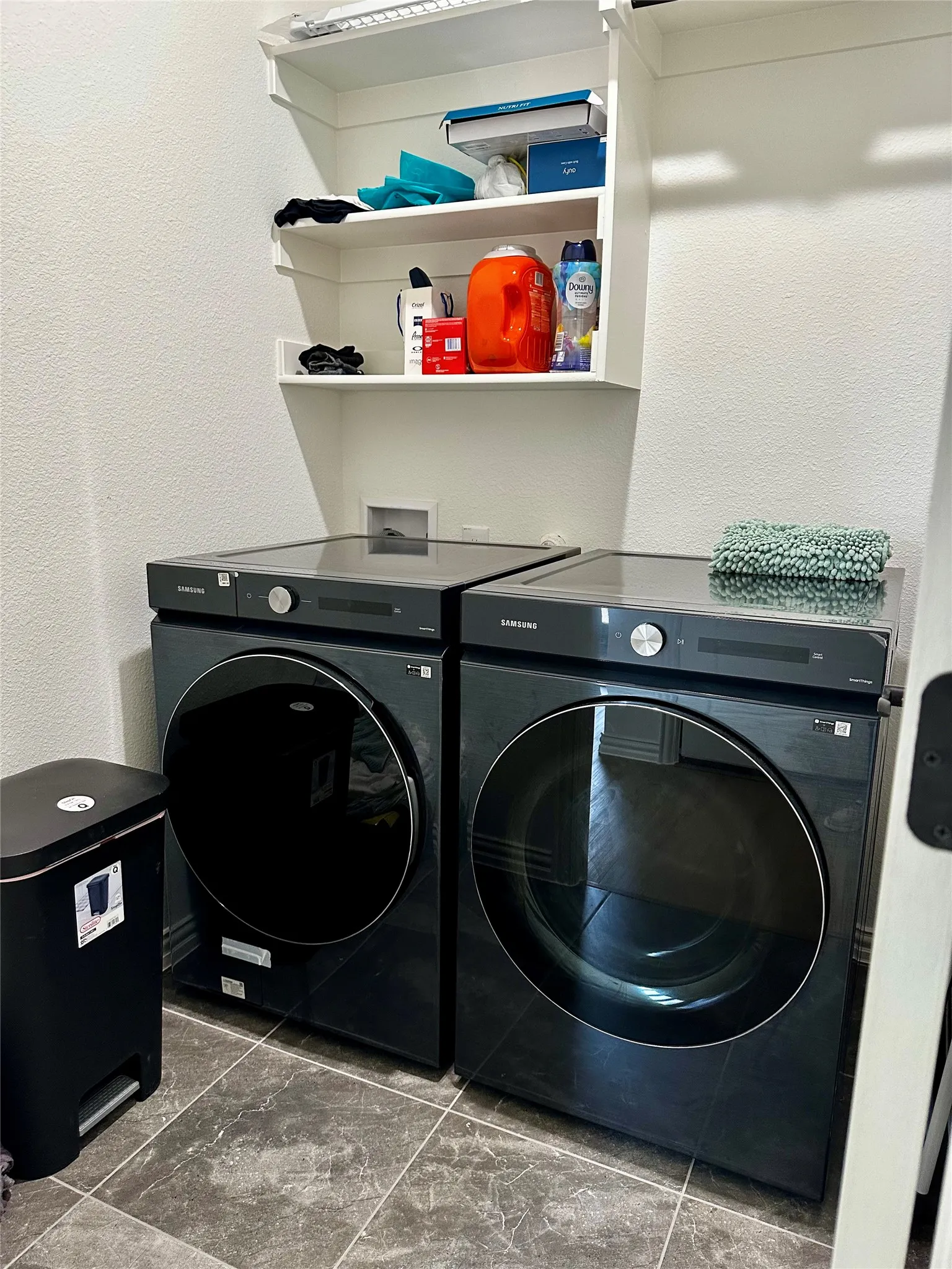 Laundry area with built-in shelving and tile flooring