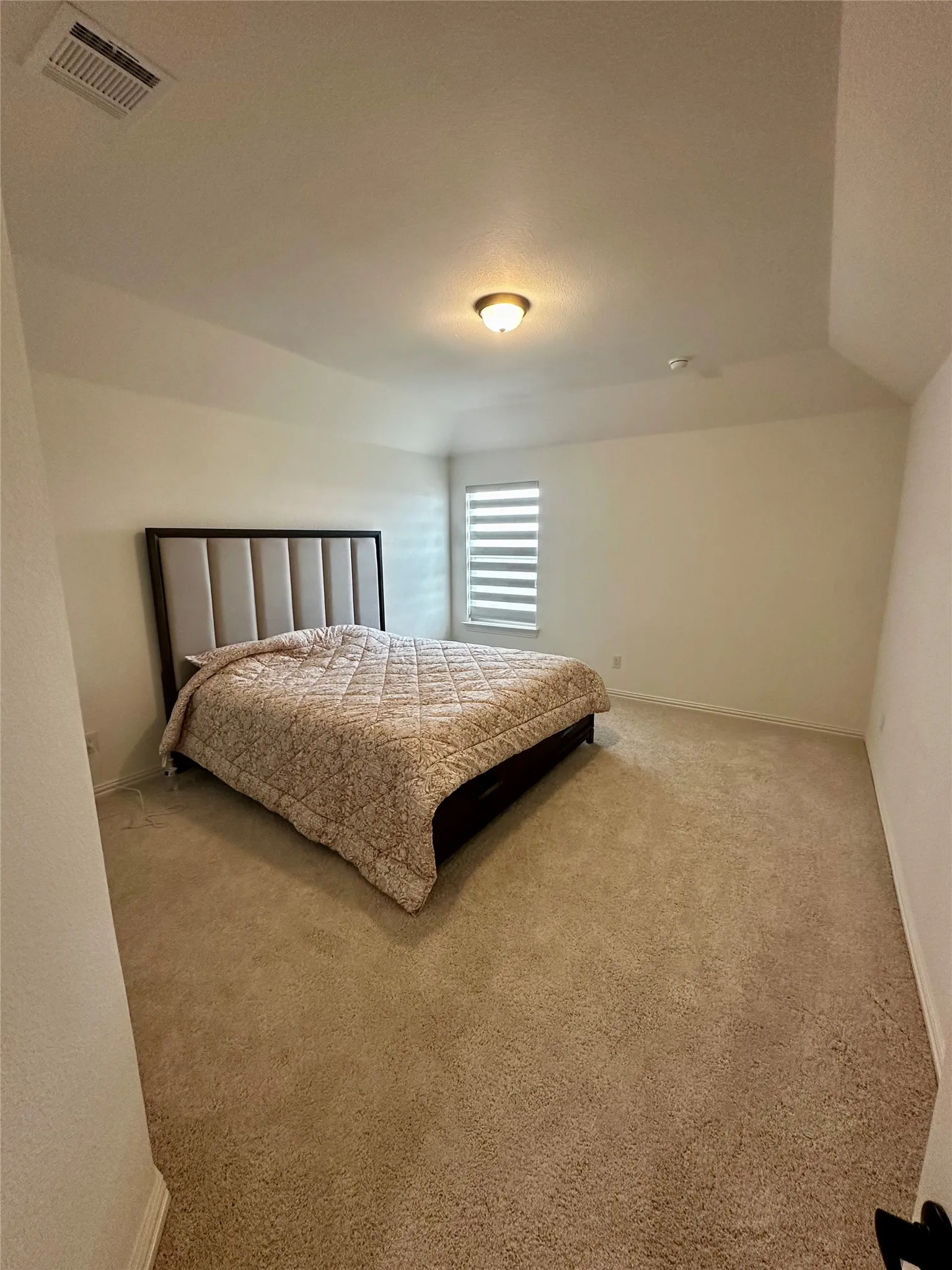 Carpeted flooring, vaulted ceiling, recessed lighting, and a window with horizontal blinds