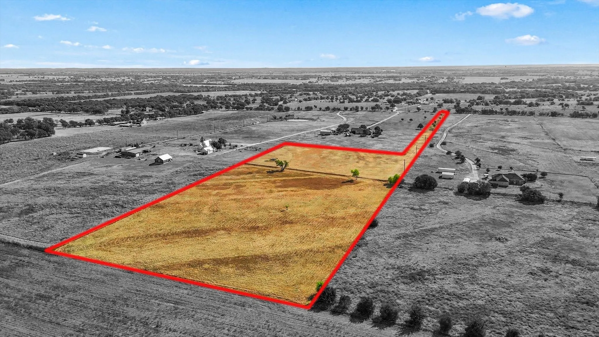 Expansive land parcel with open fields and scattered trees