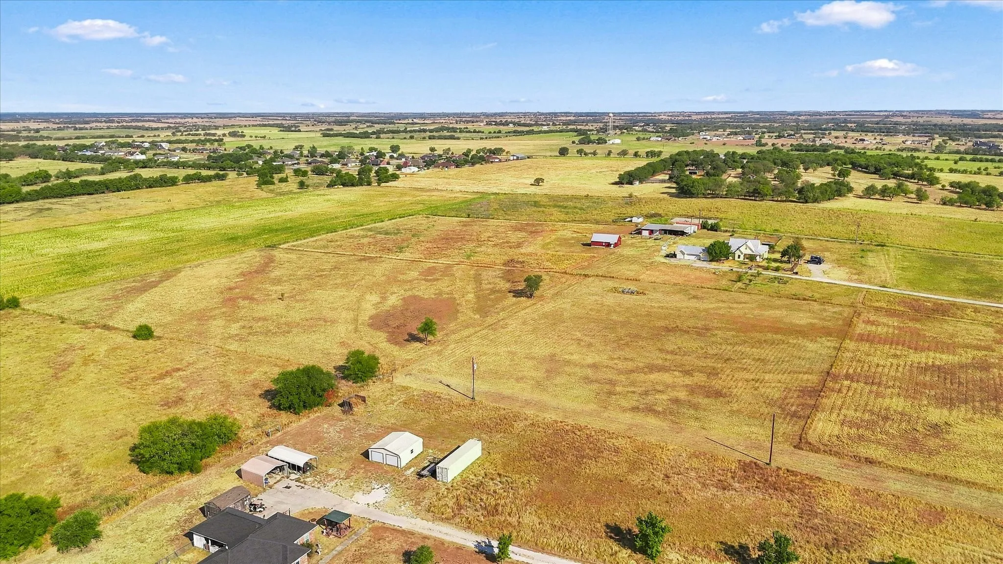 Expansive rural property featuring multiple residential structures, outbuildings, a winding unpaved road, and diverse​​‌​​​​‌​​‌‌​‌‌​​​‌‌​‌​‌​‌​​​‌​​ landscaping