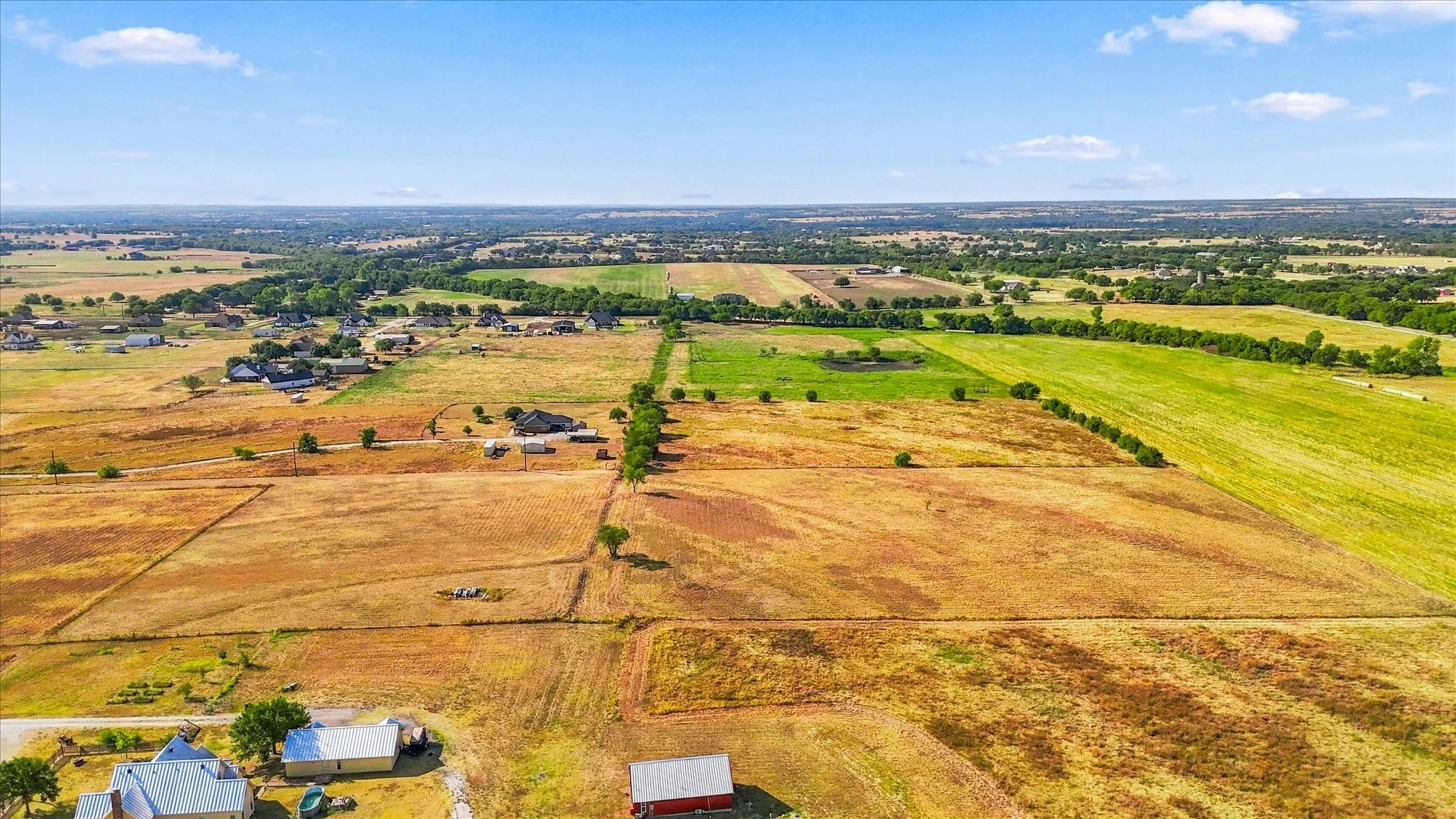 Expansive agricultural land featuring a mix of cultivated fields and scattered trees
