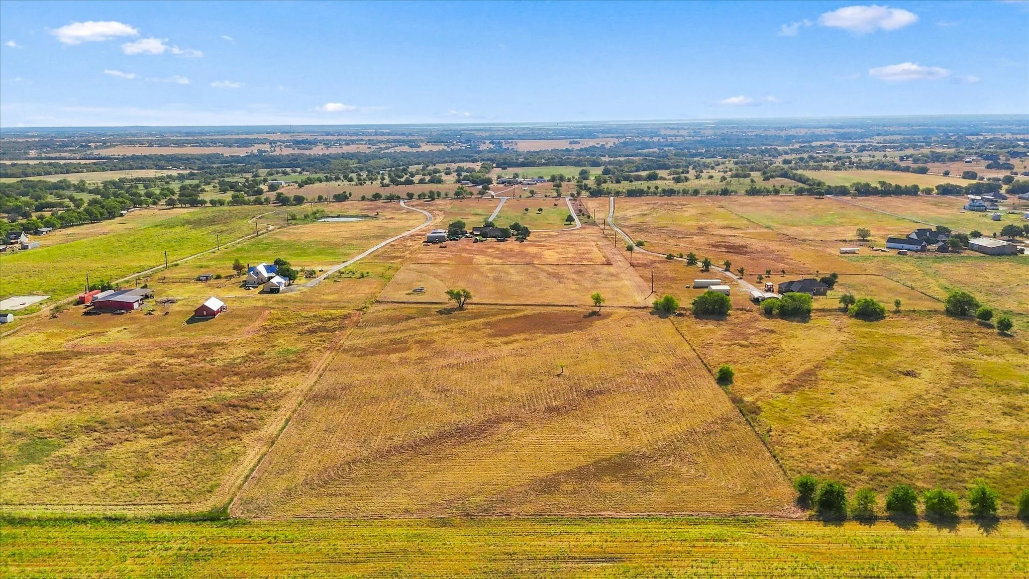 Expansive rural landscape featuring multiple parcels, scattered structures, and natural terrain