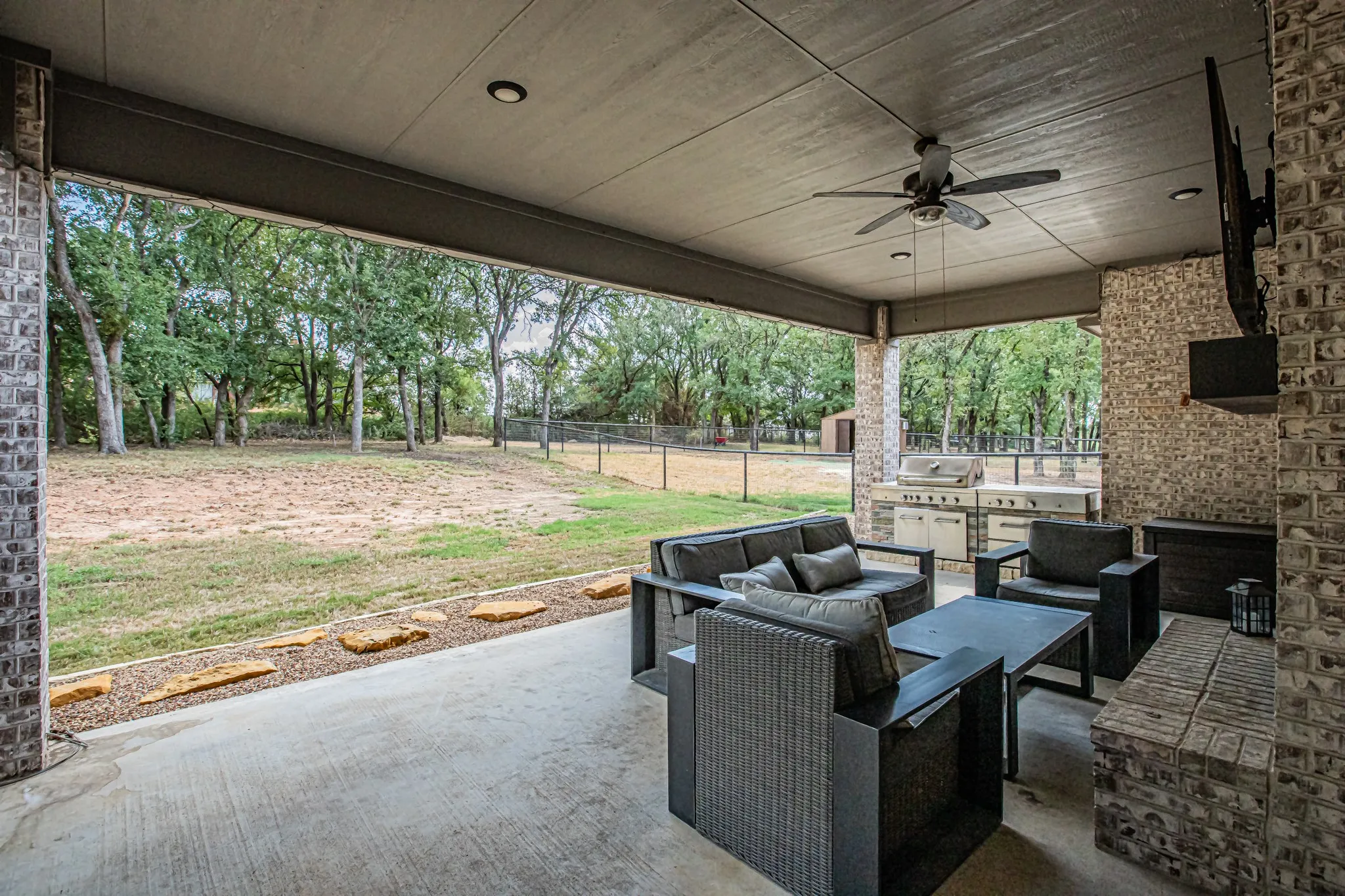 Covered patio featuring a ceiling fan, recessed lighting, and a built-in outdoor kitchen with stainless steel appliances