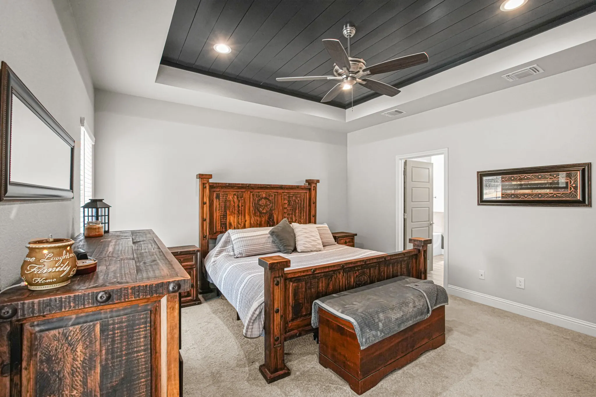 Tray ceiling with dark wood-finish paneling, recessed lighting, and a ceiling fan