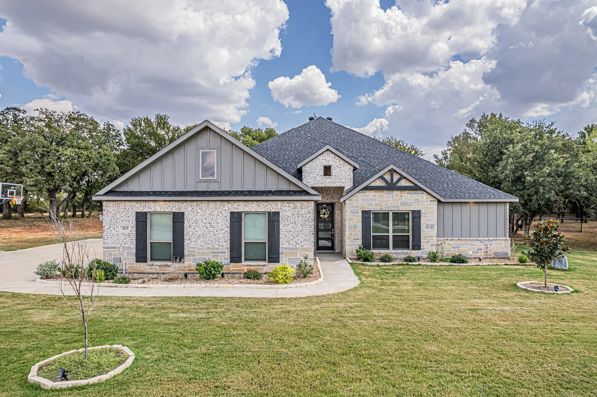Stone and board-and-batten exterior with dark-toned shutters