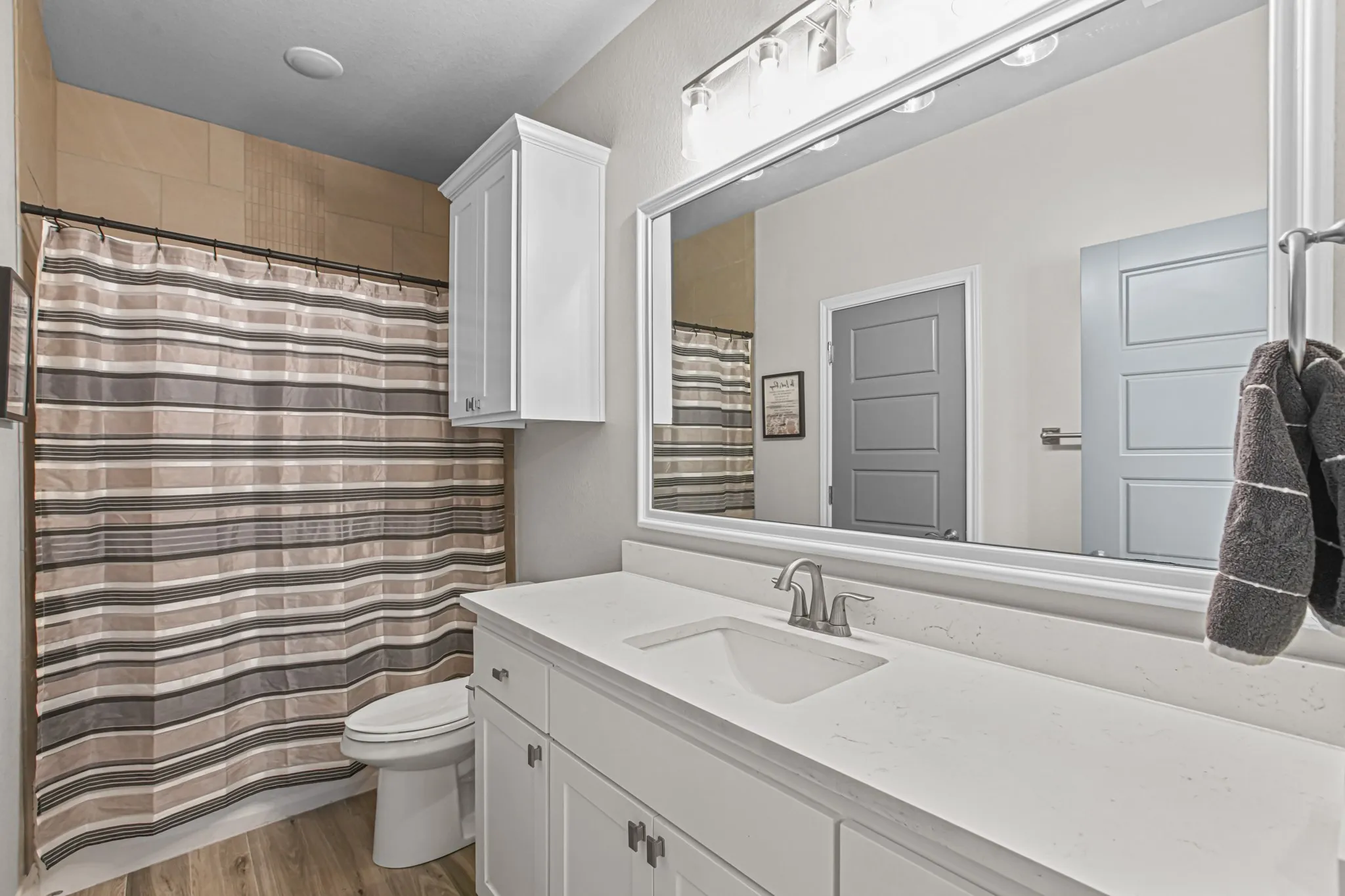 White vanity with integrated sink, light-colored countertop, and track lighting