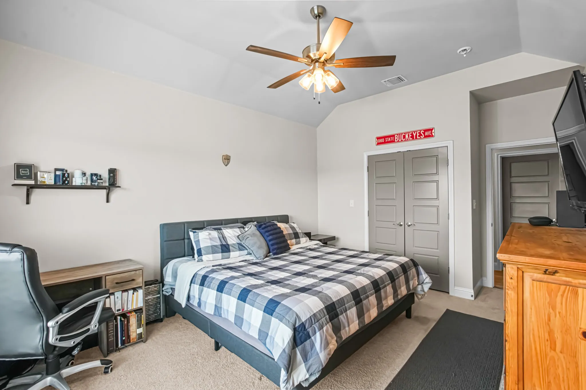 Vaulted ceiling with a ceiling fan, light-colored walls, gray paneled doors, and light-toned carpeting