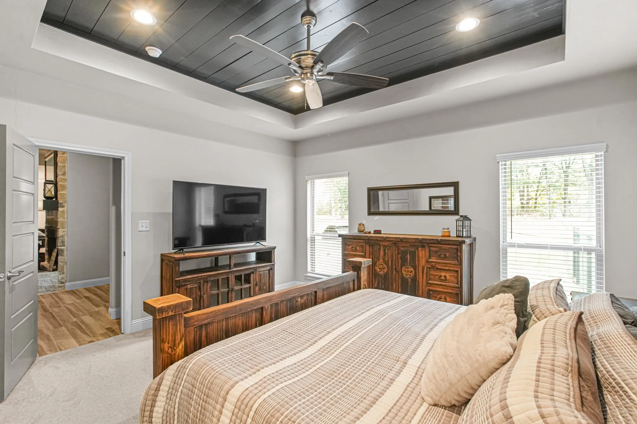 Tray ceiling with dark wood-finish planking and recessed lighting