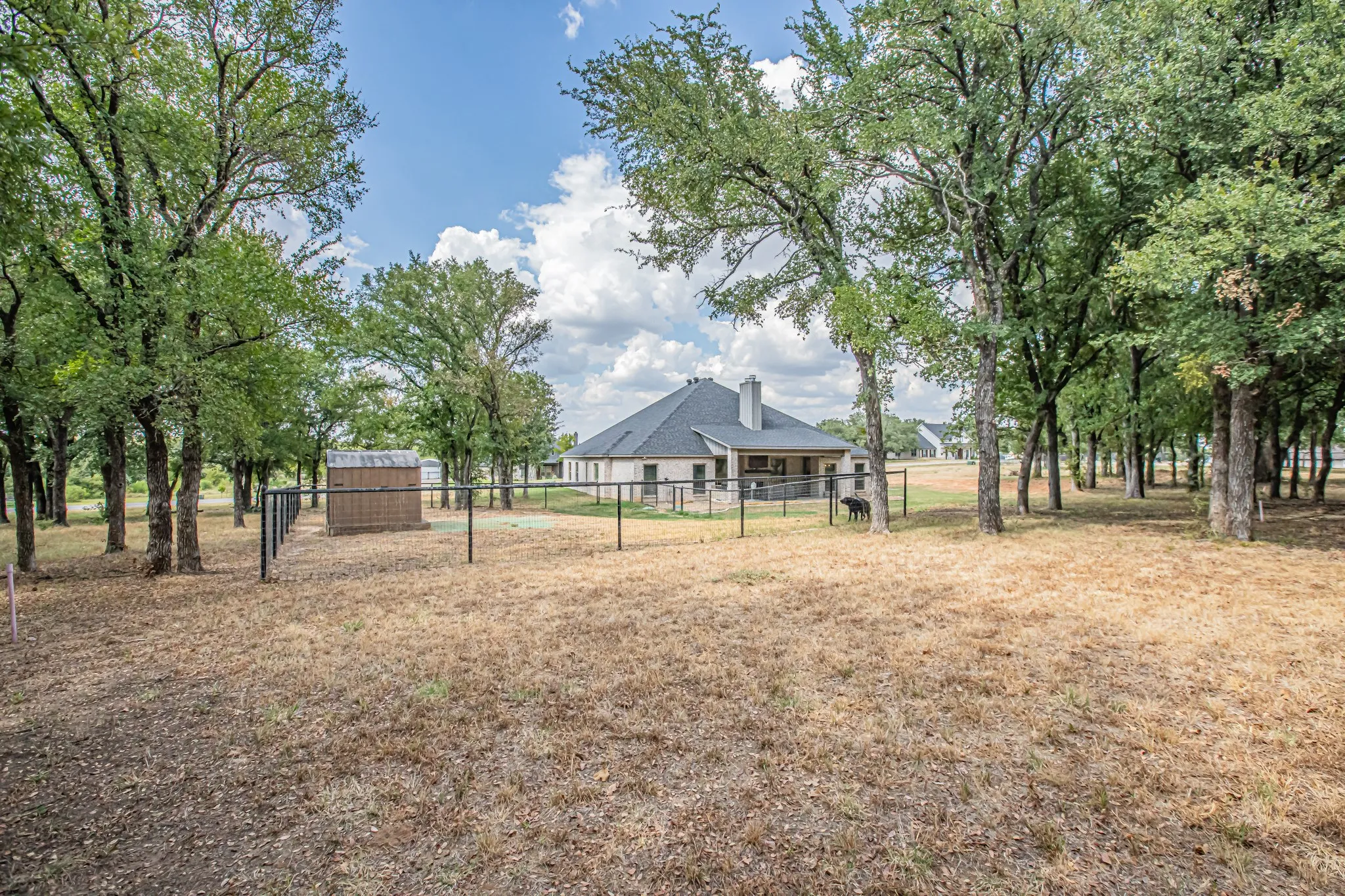 Expansive property featuring mature trees and a fenced area