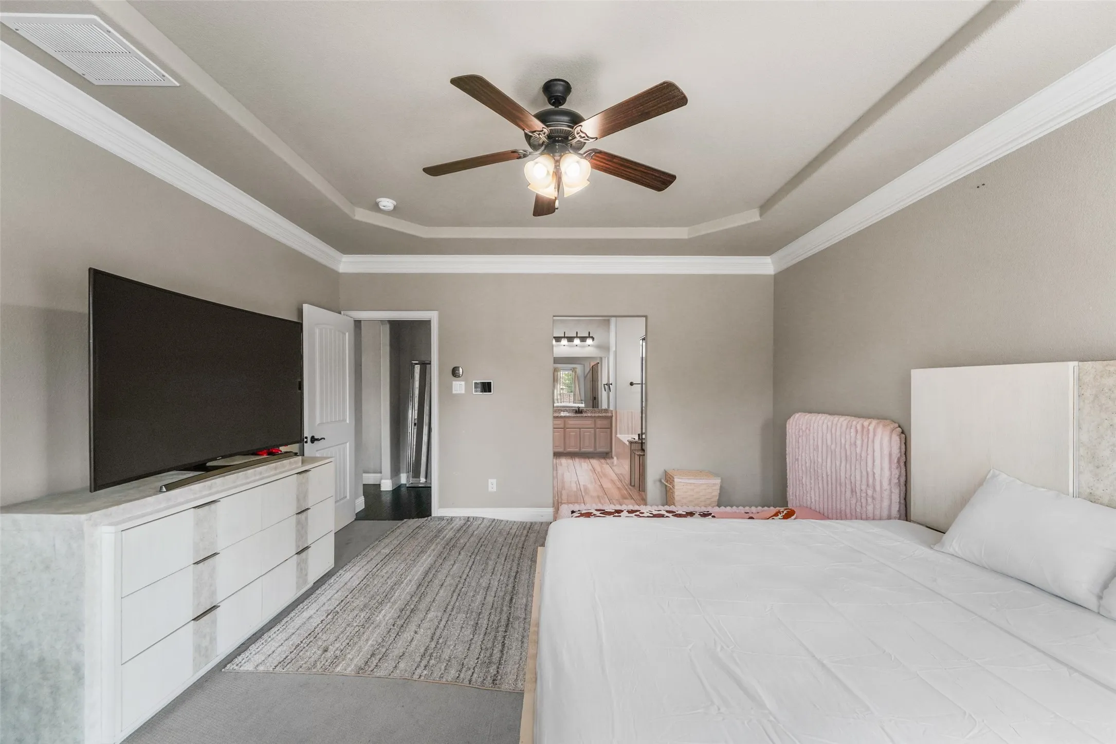 Tray ceiling with crown molding and a ceiling fan light fixture