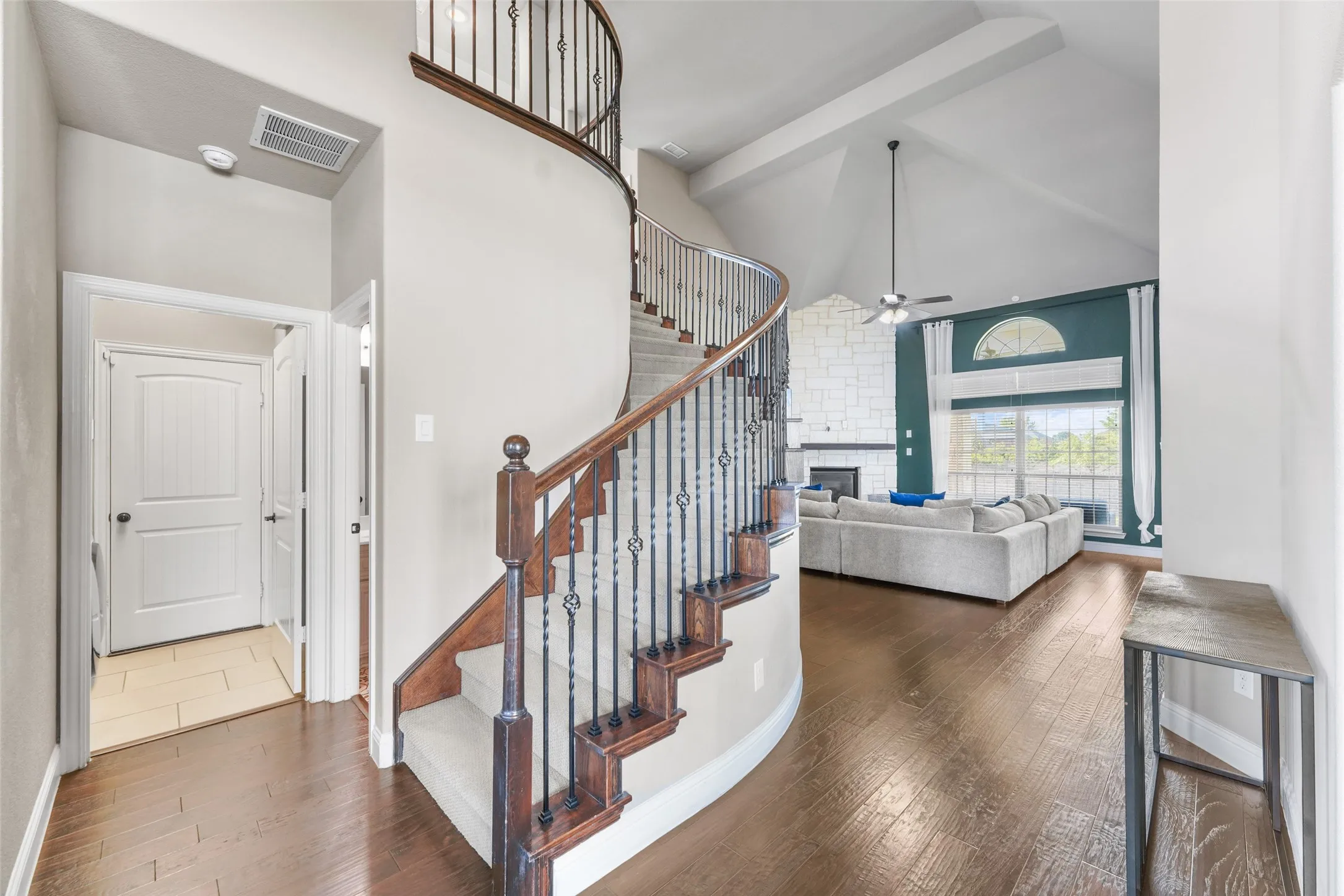 Curved staircase with wood treads and wrought iron balusters