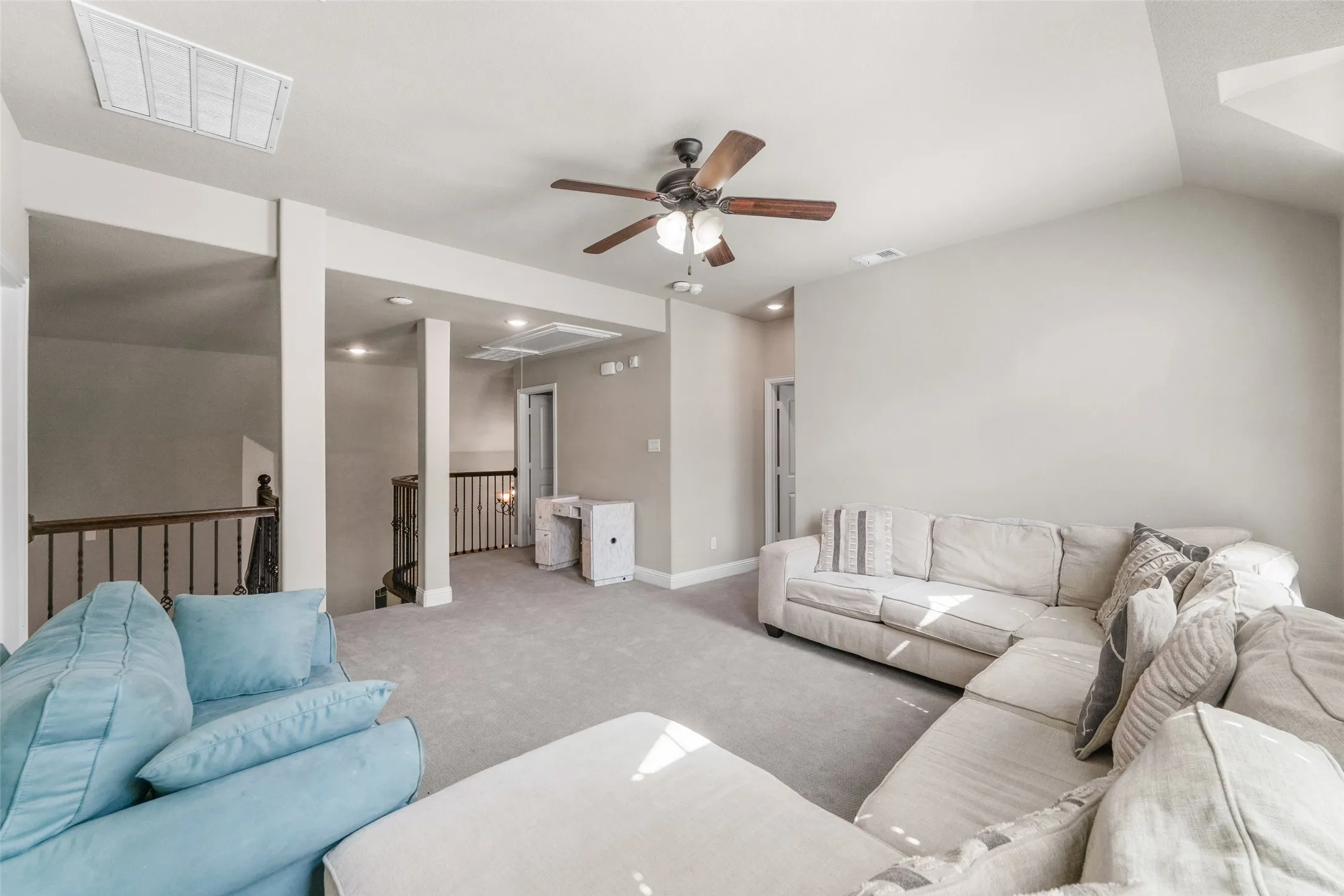 Carpeted living area with a vaulted ceiling and a ceiling fan