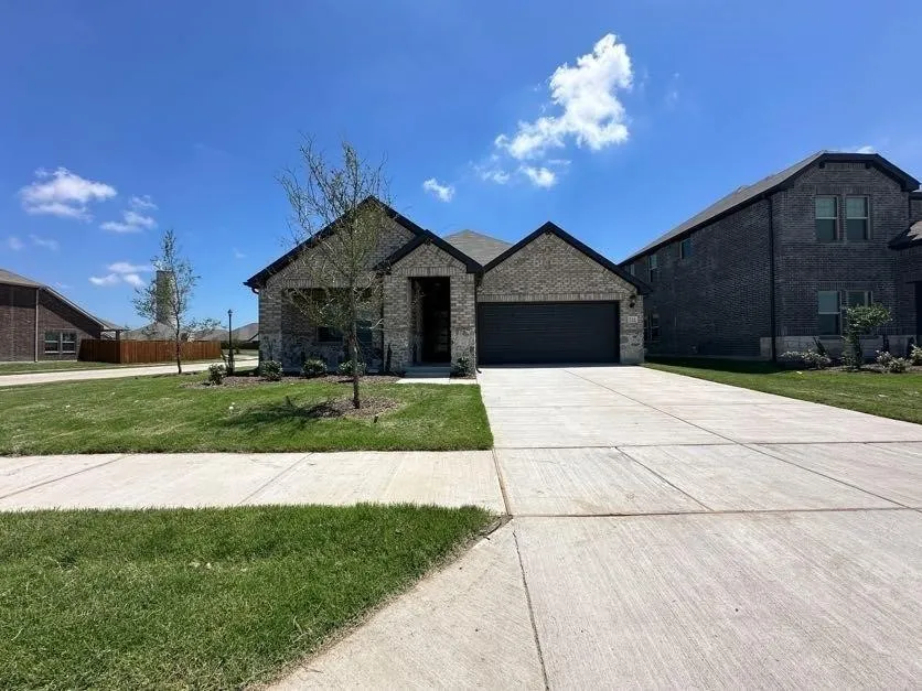 Single-story residence featuring a brick and stone facade, attached garage, and a concrete driveway