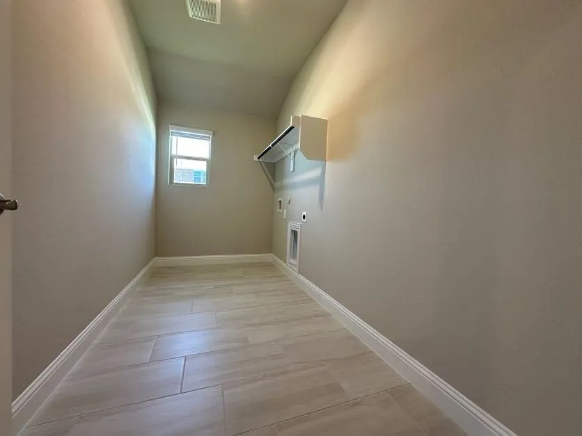 Utility room featuring tile flooring, a window, and built-in shelving