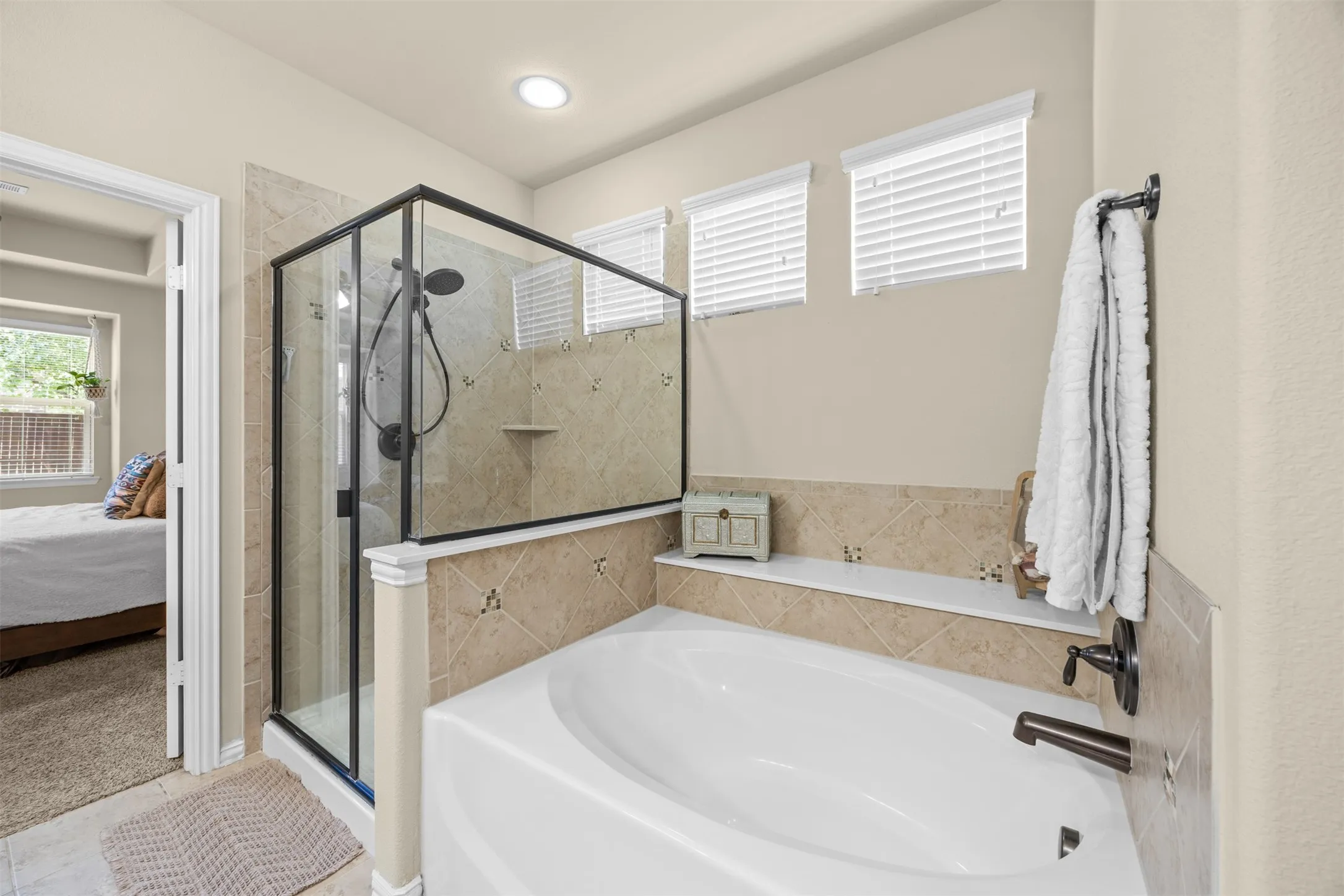 Primary bath with dual vanities, makeup vanity, soaking tub, separate walk-in shower and spacious closet.