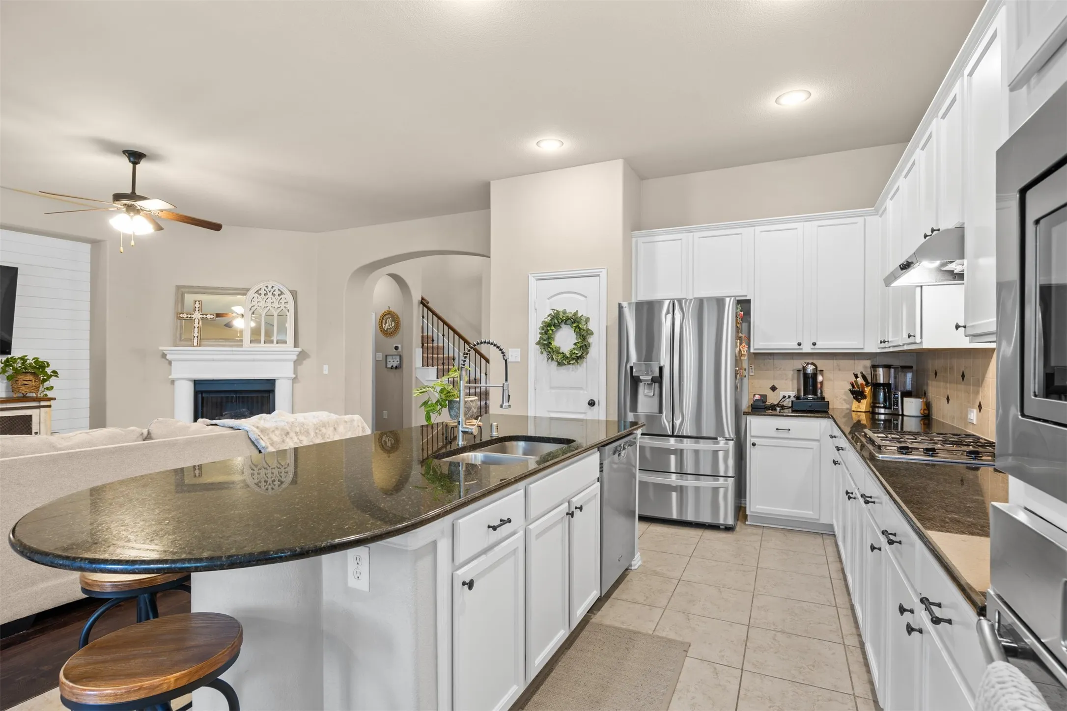 Spacious kitchen with oversized granite island, seating, gas cooktop, built-in oven and microwave, stainless steel appliances and abundant cabinetry