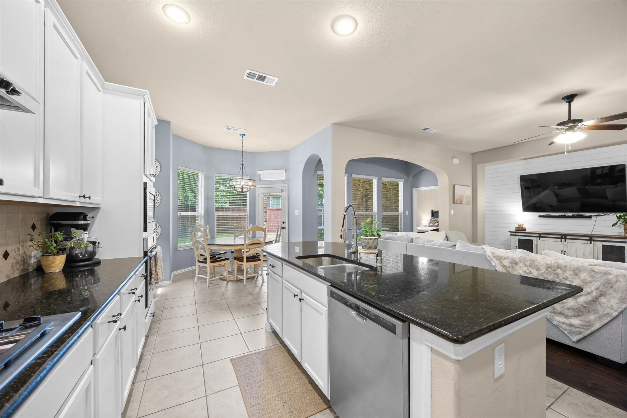 Spacious kitchen with oversized granite island, seating, gas cooktop, built-in oven and microwave, stainless steel appliances and abundant cabinetry