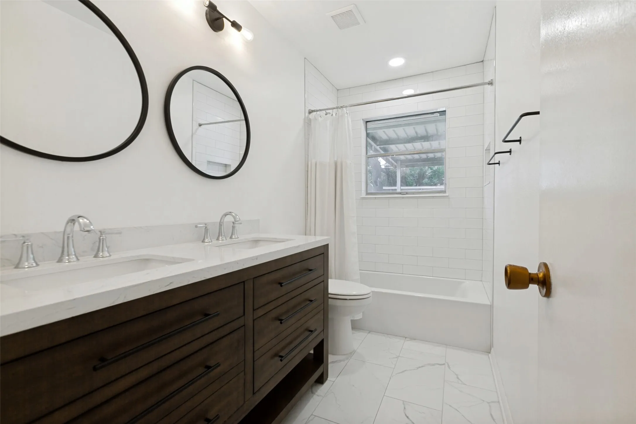 Dual vanity with white countertop, chrome fixtures, and dark wood-finish cabinetry