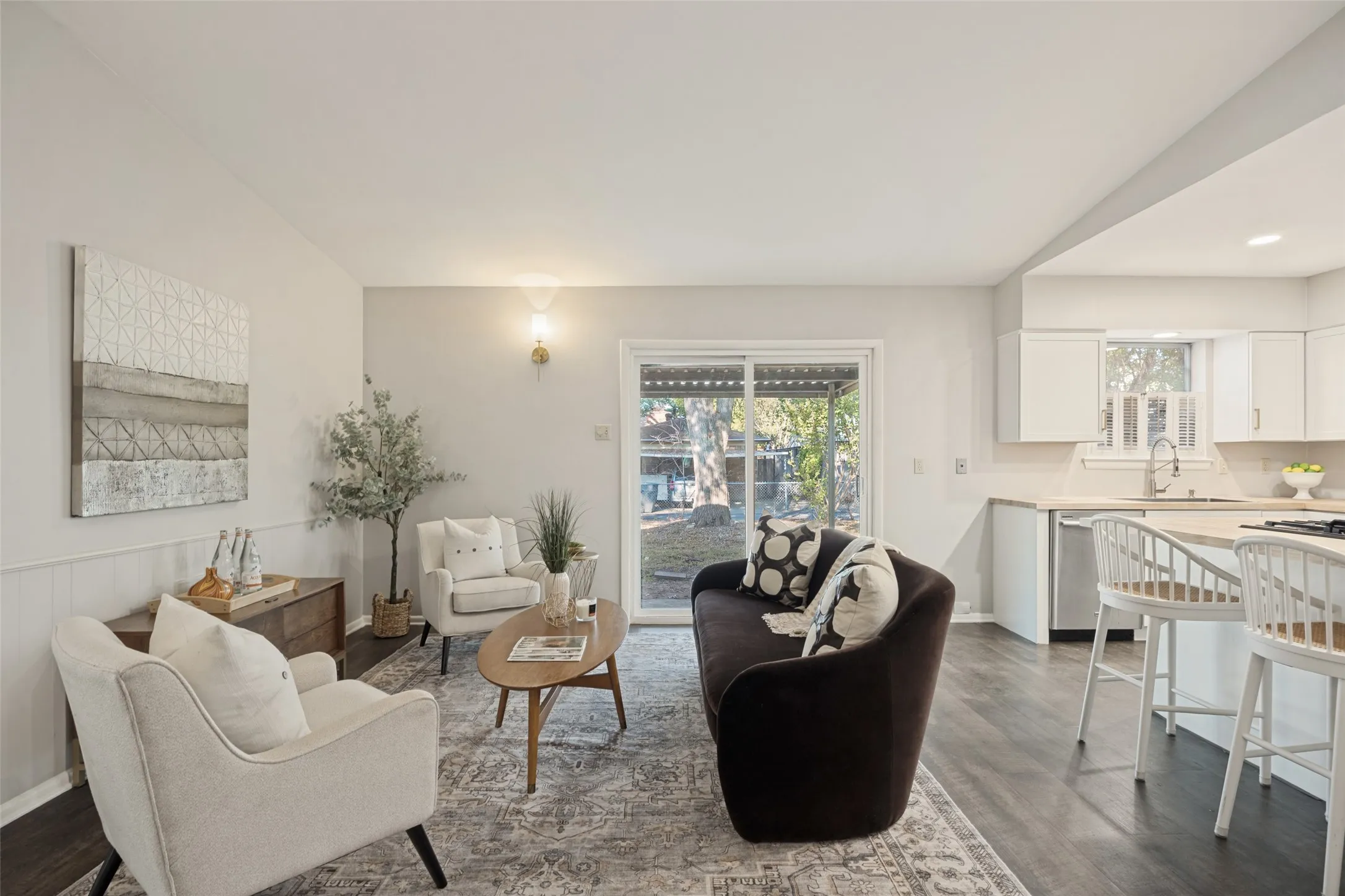 Open-concept living area featuring wood-finish flooring, a vaulted ceiling, and a sliding glass door to the exterior